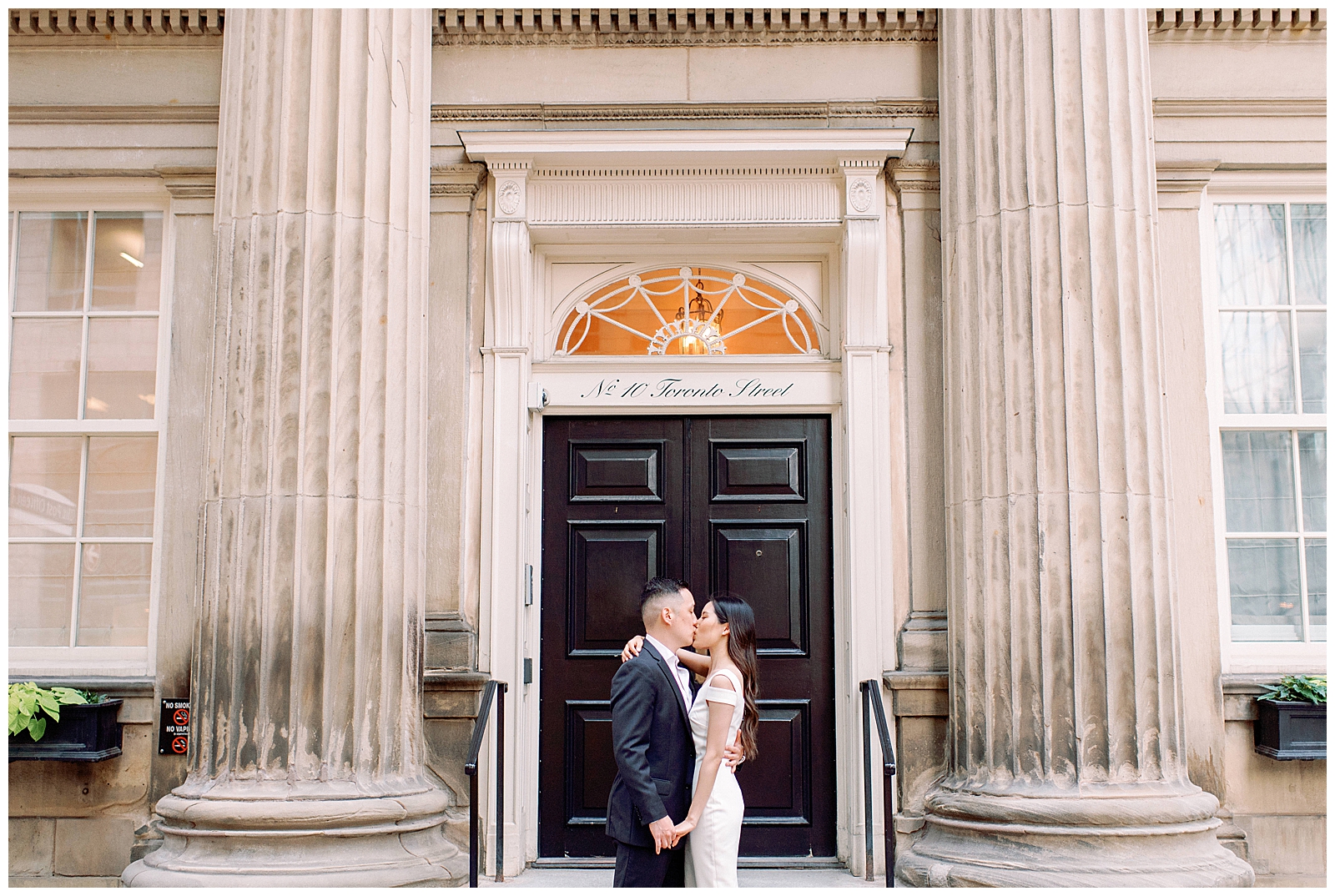 Downtown Toronto Financial District Engagement Session Modern Chic Timeless Couple Embracing in Front of Beautiful Door | Toronto Wedding Photography Jacqueline James Photography