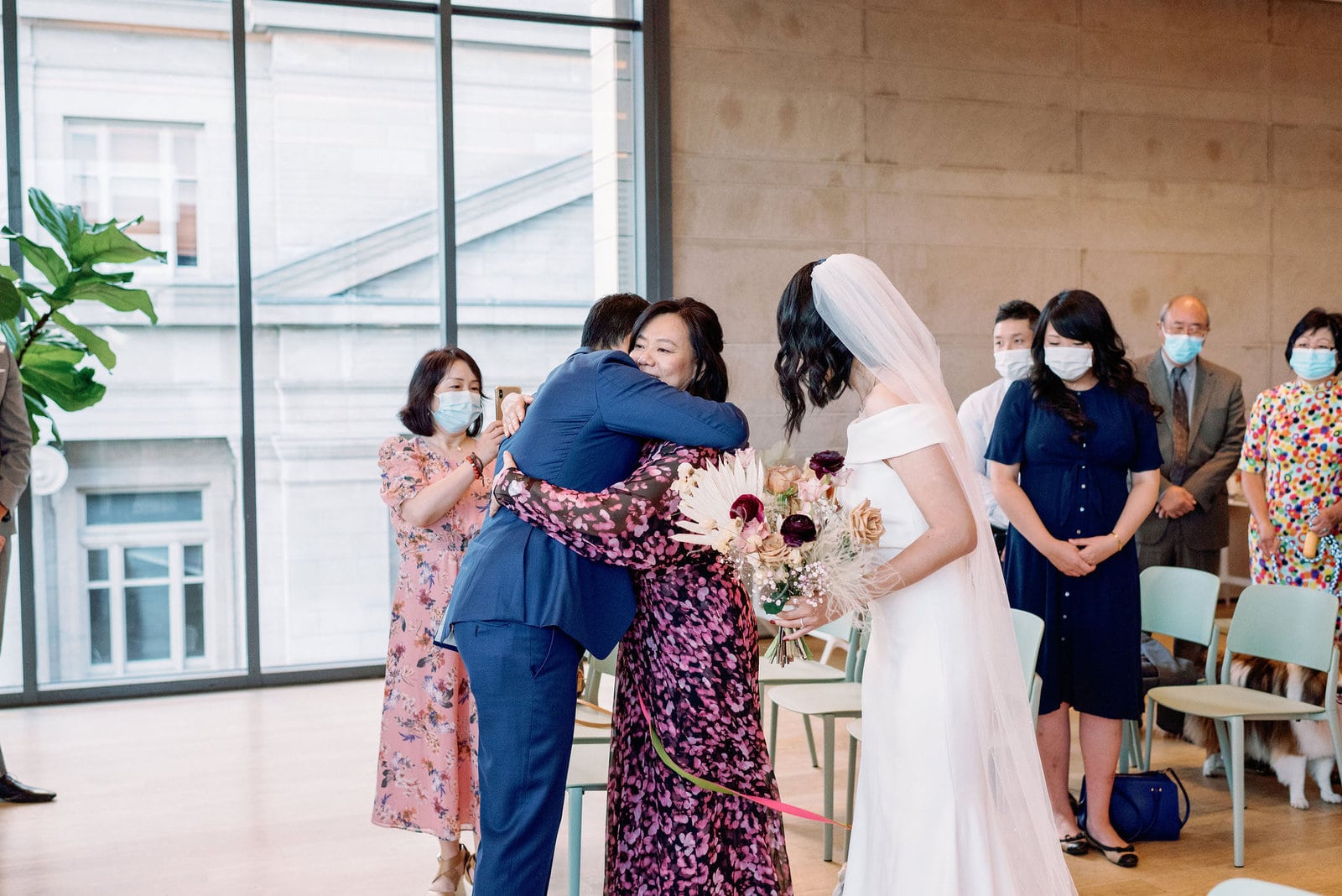Groom emotional sweet embrace with mother in law at Ceremony at gardiner museum downtown toronto modern romantic wedding jacqueline james photography