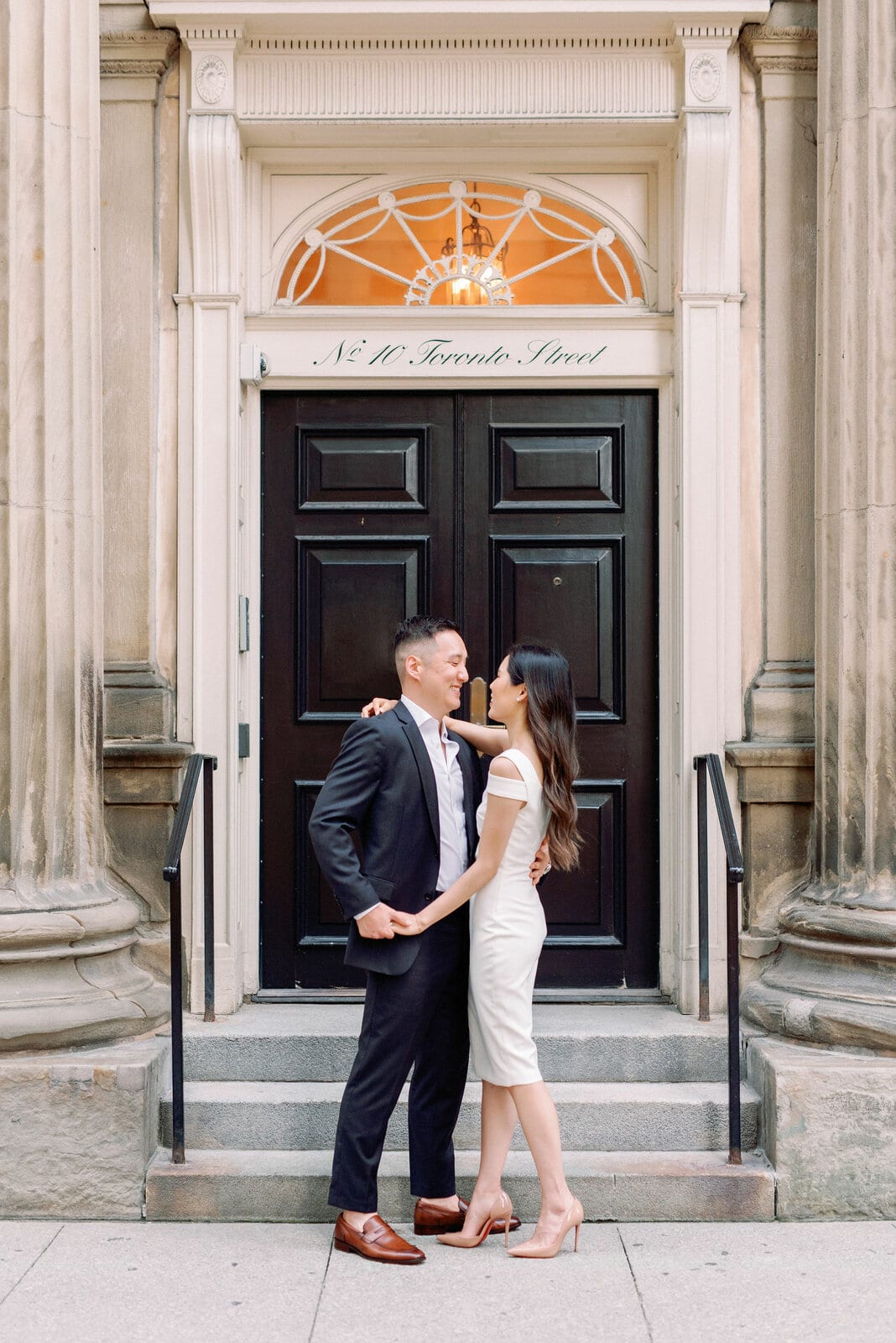 Downtown Toronto Engagement Photos Financial District Modern Chic Timeless Couple Embracing in Front of Beautiful Door | Toronto Wedding Photography Jacqueline James Photography