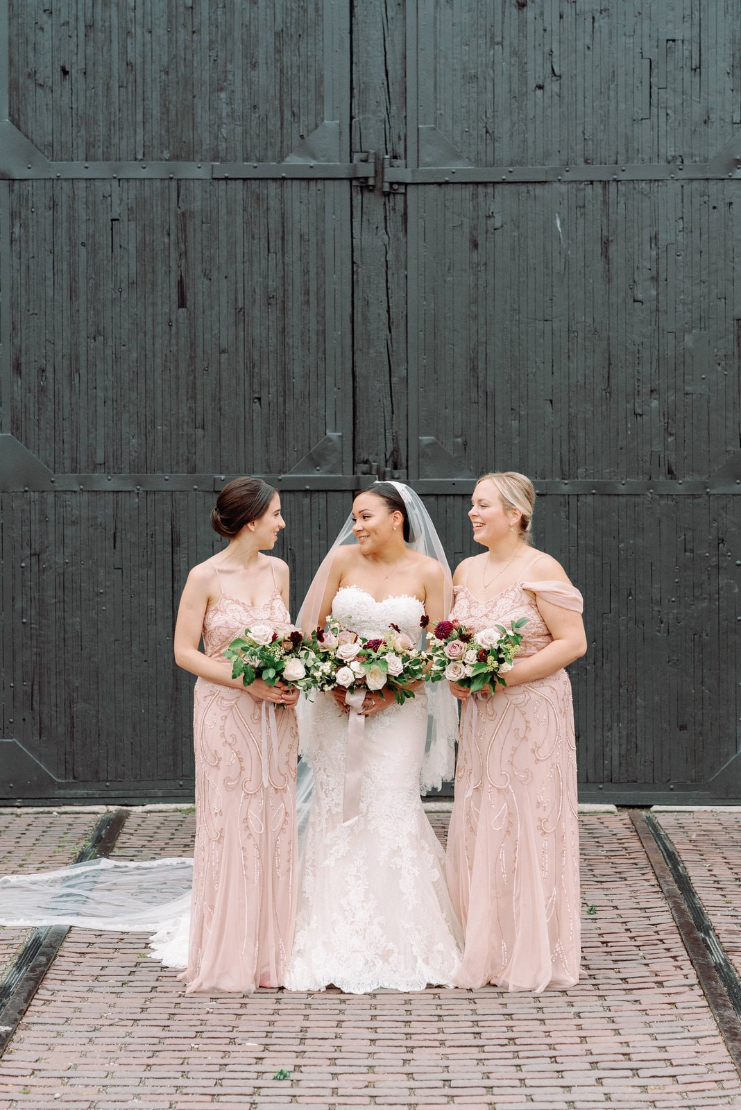 bride and bridesmaids smile outside steam whistle brewery featured by martha stewart weddings steam whistle wedding toronto wedding venue jacqueline james photography