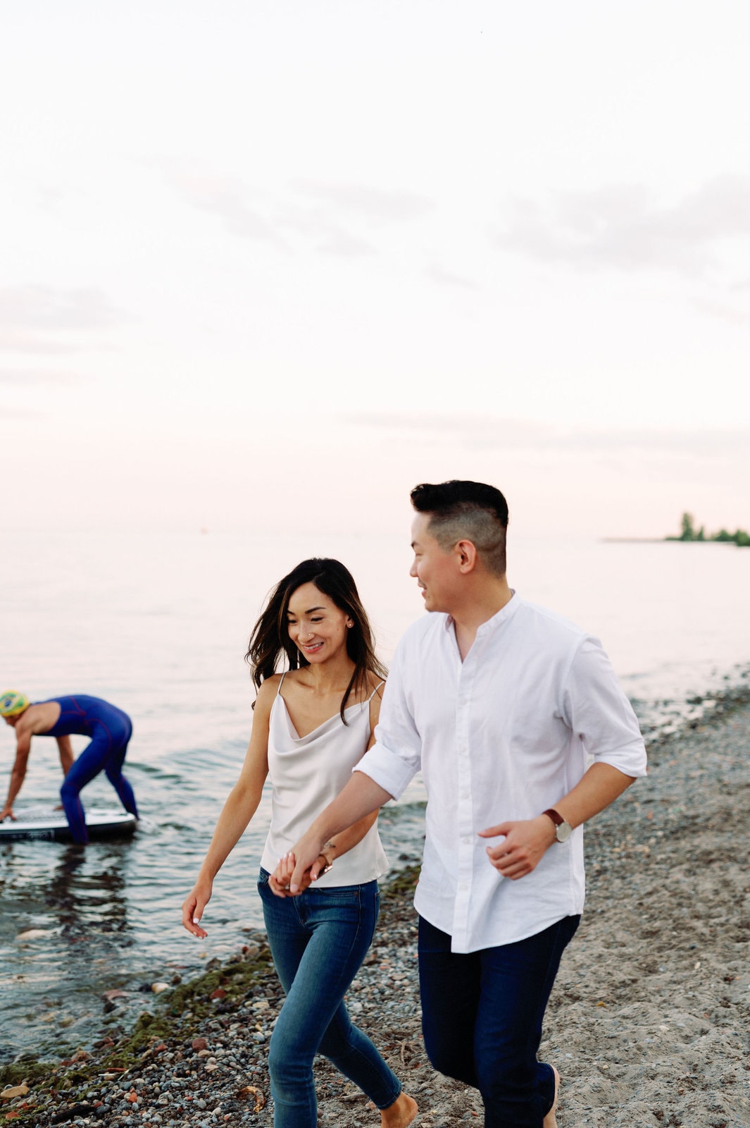Toronto Beach Engagement Session Couple Walking along Cherry Beach Summer Sunset Romantic Embrace Lifeguard Dock Lake Ontario