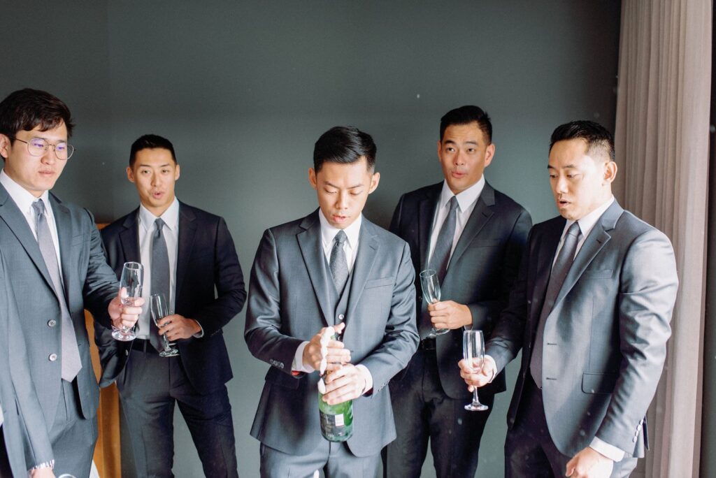 Groom Celebrates with Champagne with Groomsmen Happy Candid Fun Morning Aga Khan Museum Wedding Toronto Wedding Venue Jacqueline James Photography