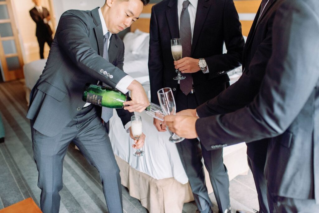 Groom Celebrates with Champagne with Groomsmen Happy Candid Fun Morning Aga Khan Museum Wedding Toronto Wedding Venue Jacqueline James Photography