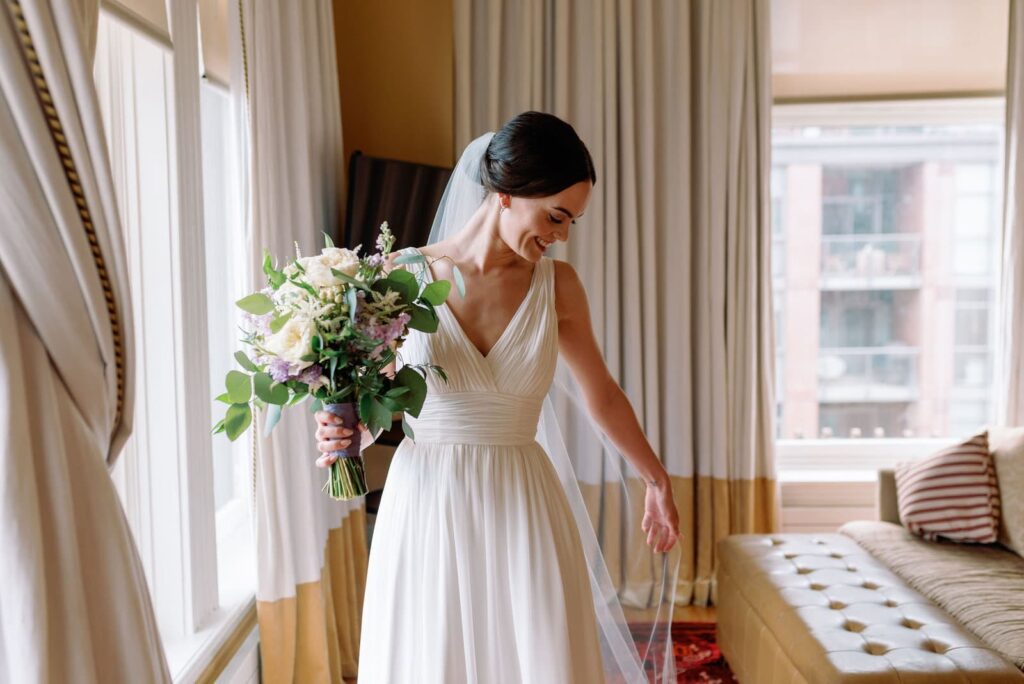 candid moment of bride delicately playing with wedding dress at Gladstone House Wedding Toronto Wedding Venue Jacqueline James Photography