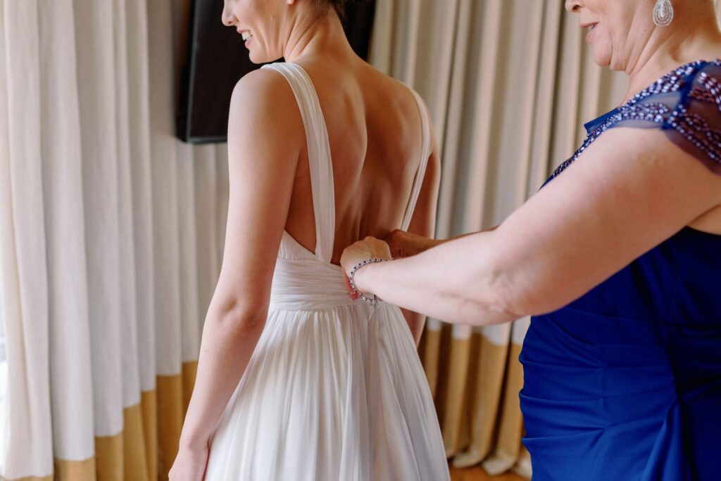 mother helps bride into wedding dress at Gladstone House Wedding Toronto Wedding Venue Jacqueline James Photography