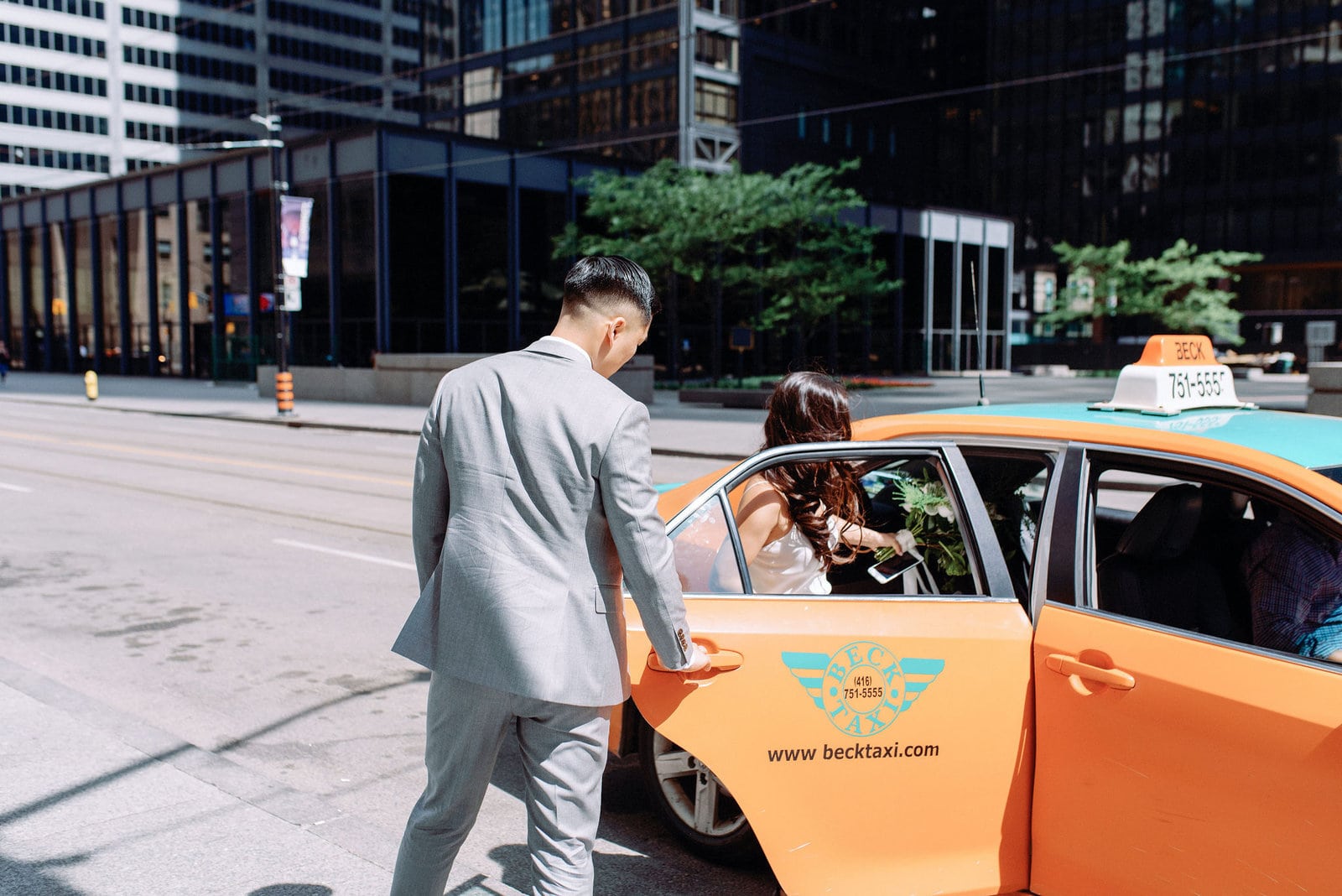 Bride and Groom Hailing a Cab on Wedding Day Heading to Hotel Ocho Financial District Downtown Toronto Wedding Photographer Jacqueline James Photography