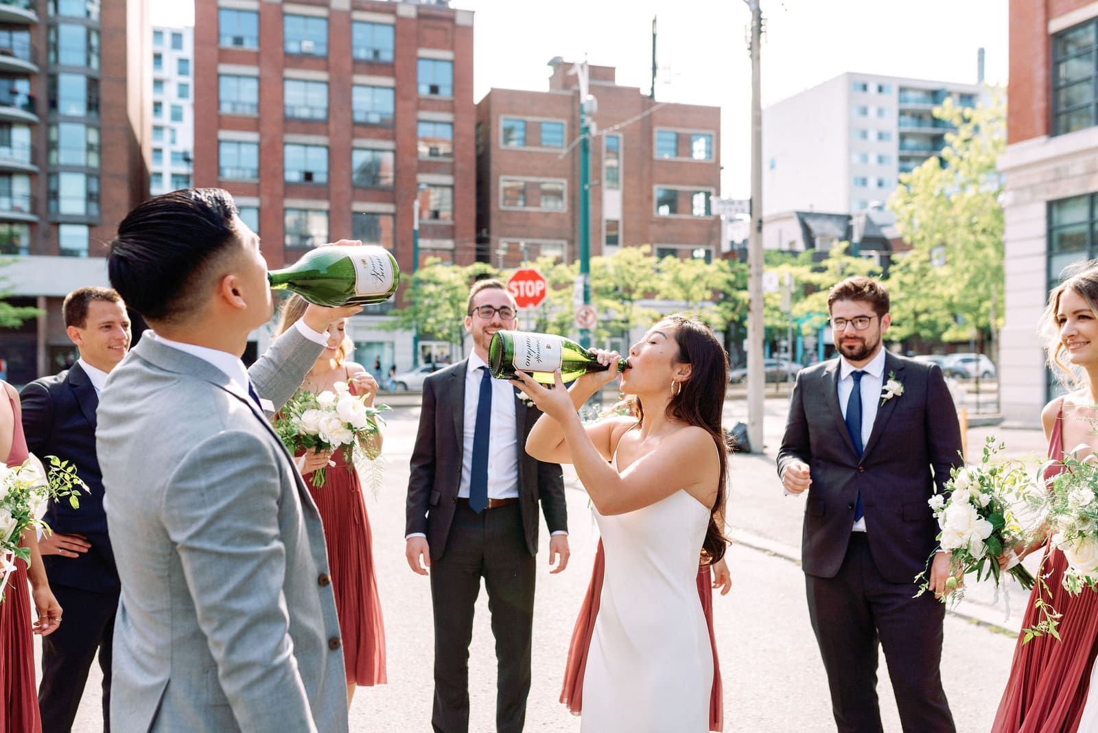 Champagne Spray Celebration in the streets Happy Joyful Spontaneous Fun with Bride and Groom and Wedding Party Downtown Toronto Wedding Photographer Jacqueline James Photography