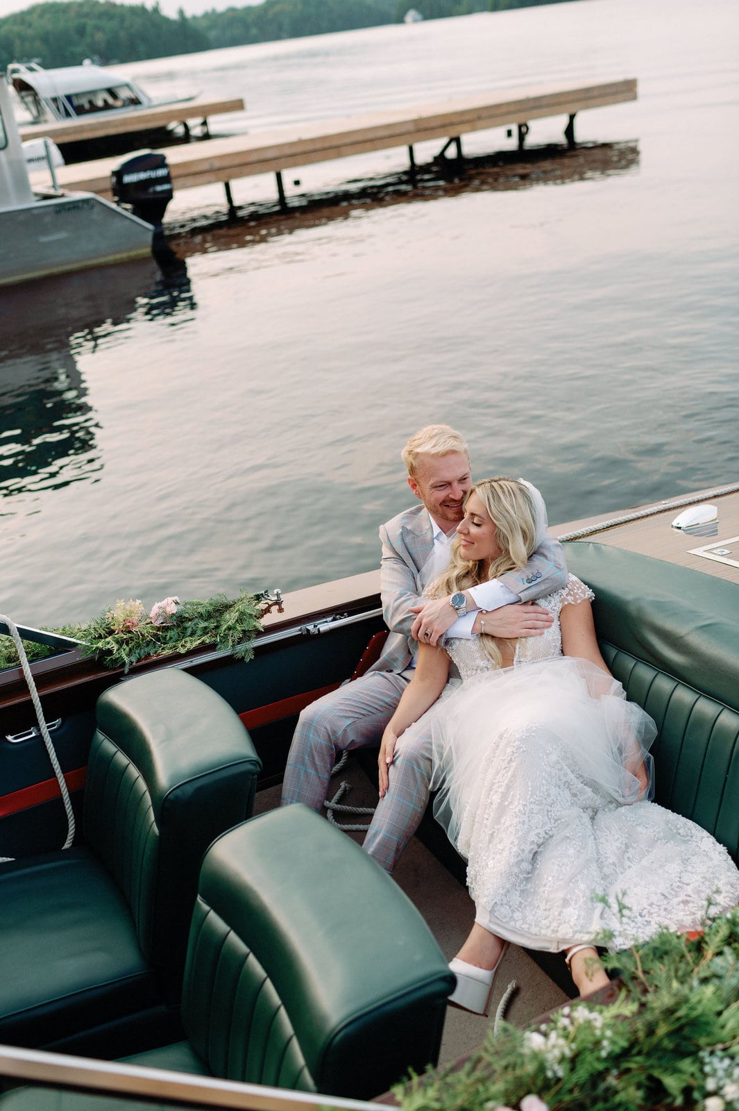 Editorial Bride and Groom relax on wooden boat in Muskoka Lakes wedding venue Jacqueline James Photography