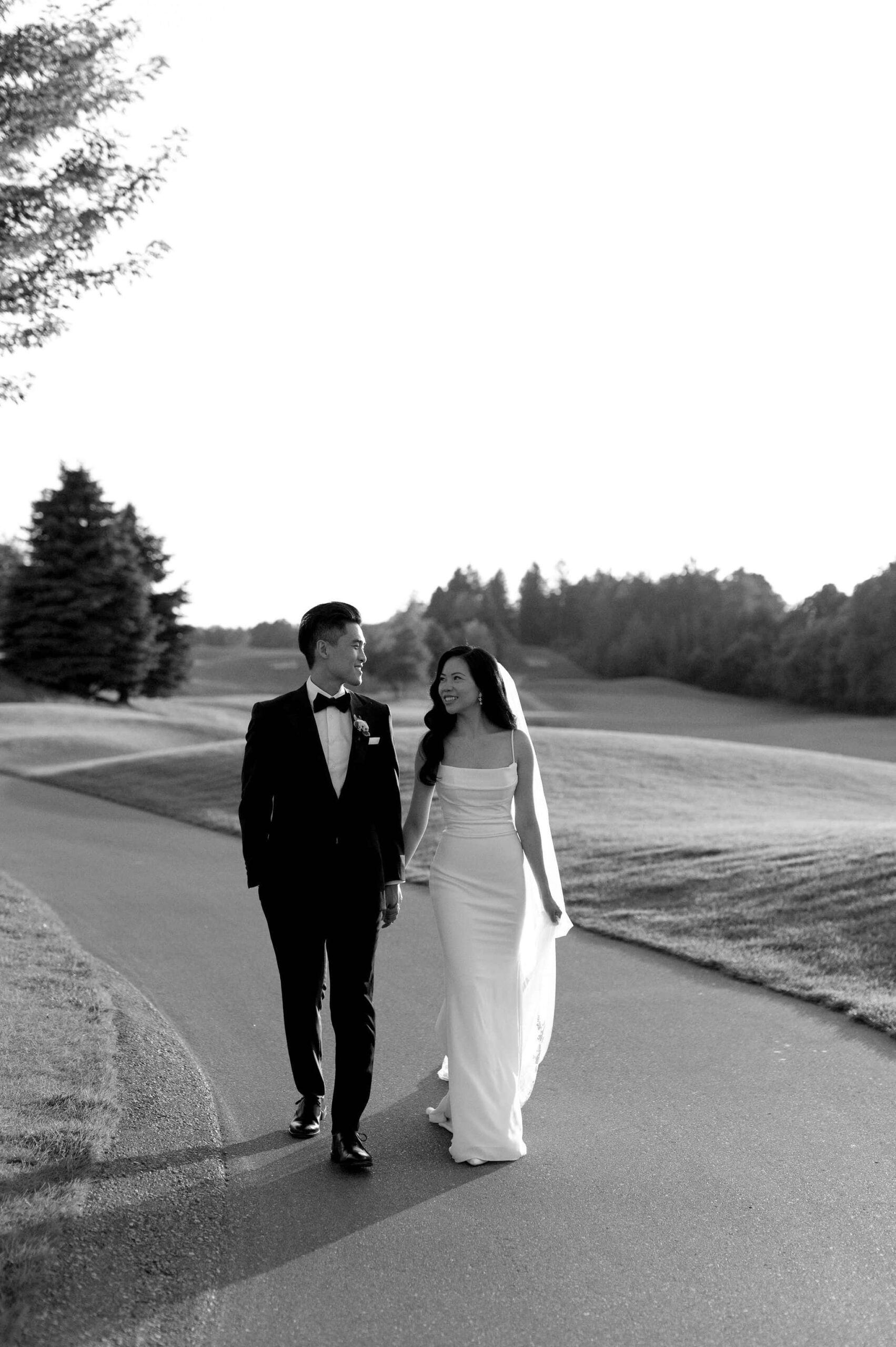 modern editorial timeless wedding portrait at sunset golden hour bride and groom walking at whistle bear golf club wedding cambridge