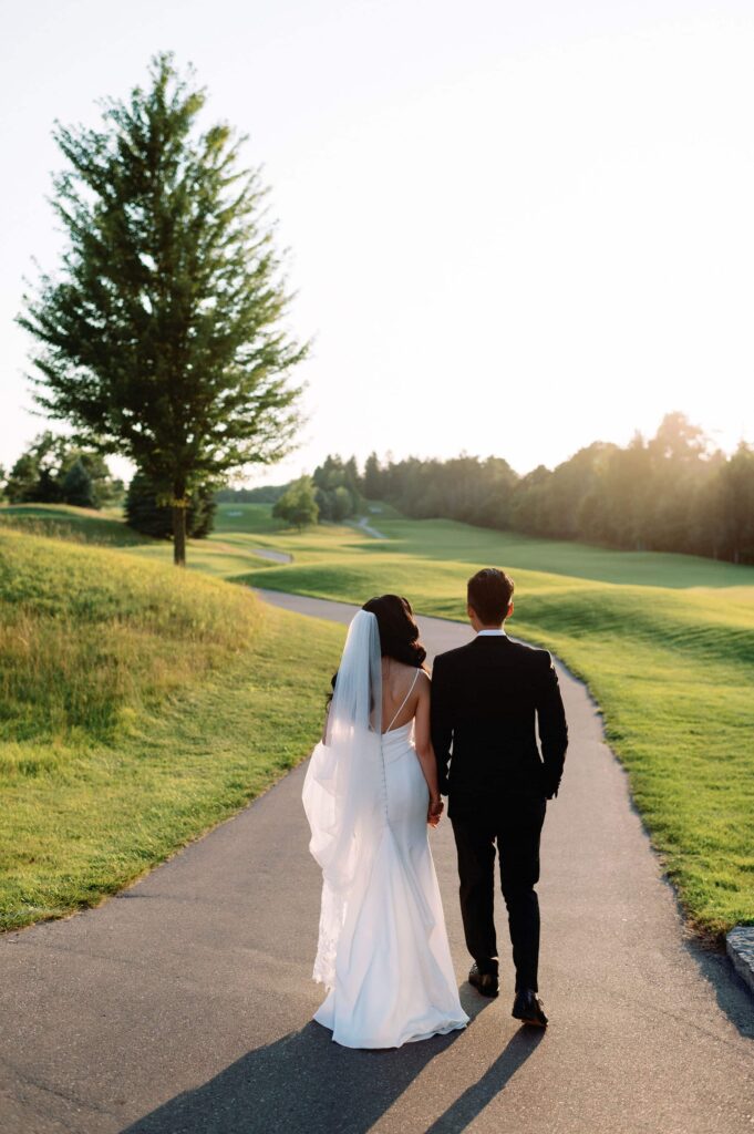 modern editorial timeless wedding portrait at sunset golden hour bride and groom walking at whistle bear golf club wedding cambridge