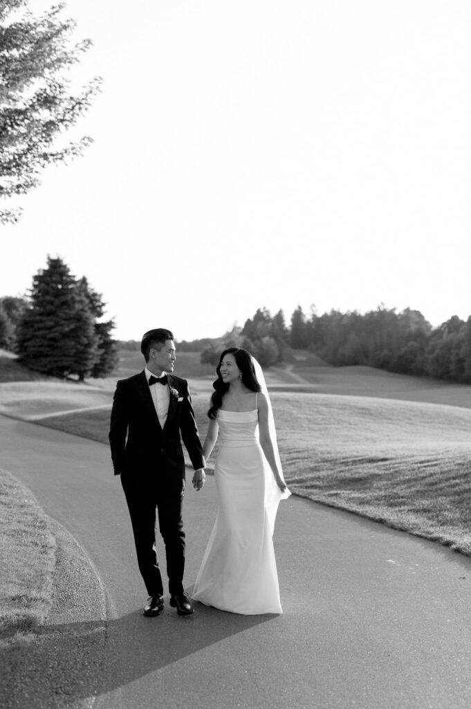 modern editorial timeless wedding portrait at sunset golden hour bride and groom walking at whistle bear golf club wedding cambridge