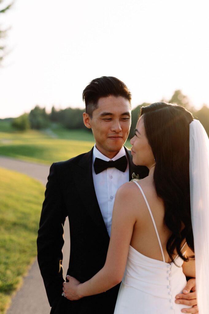 modern editorial timeless wedding portrait at sunset golden hour bride and groom walking at whistle bear golf club wedding cambridge