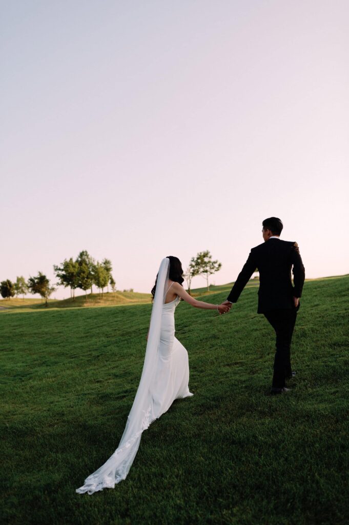 modern editorial timeless wedding portrait at sunset golden hour bride and groom walking at whistle bear golf club wedding cambridge