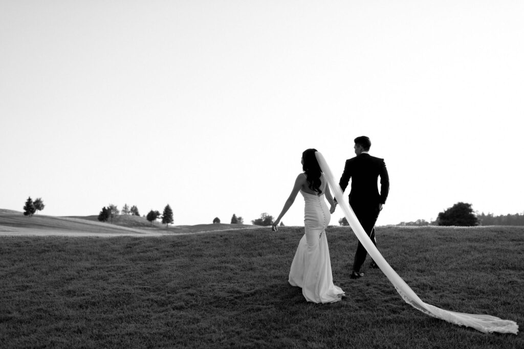 modern editorial timeless wedding portrait at sunset golden hour bride and groom walking at whistle bear golf club wedding cambridge