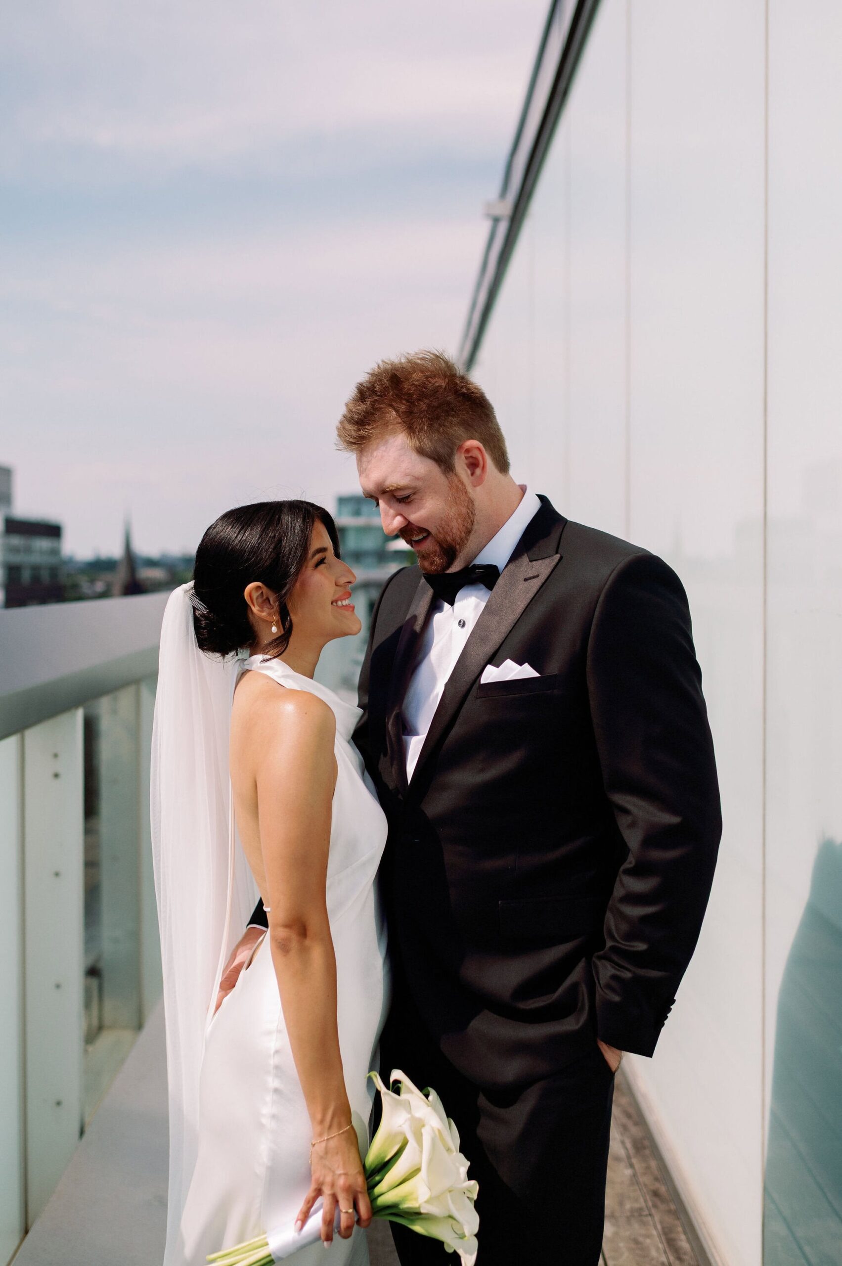 Bride and groom on rooftop balcony with CN Tower skyline view at 1 Hotel Toronto