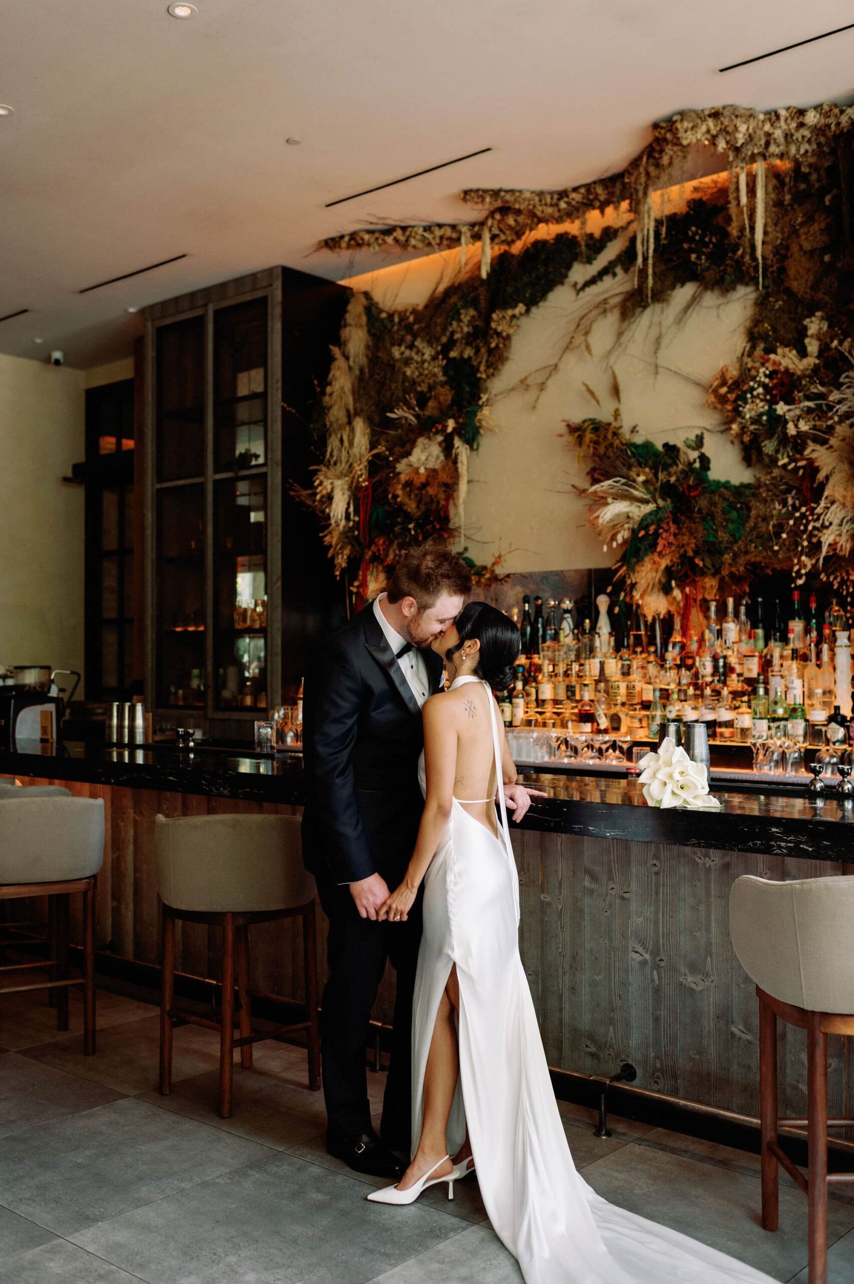 Bride and groom embrace at modern bar inside 1 Hotel Toronto