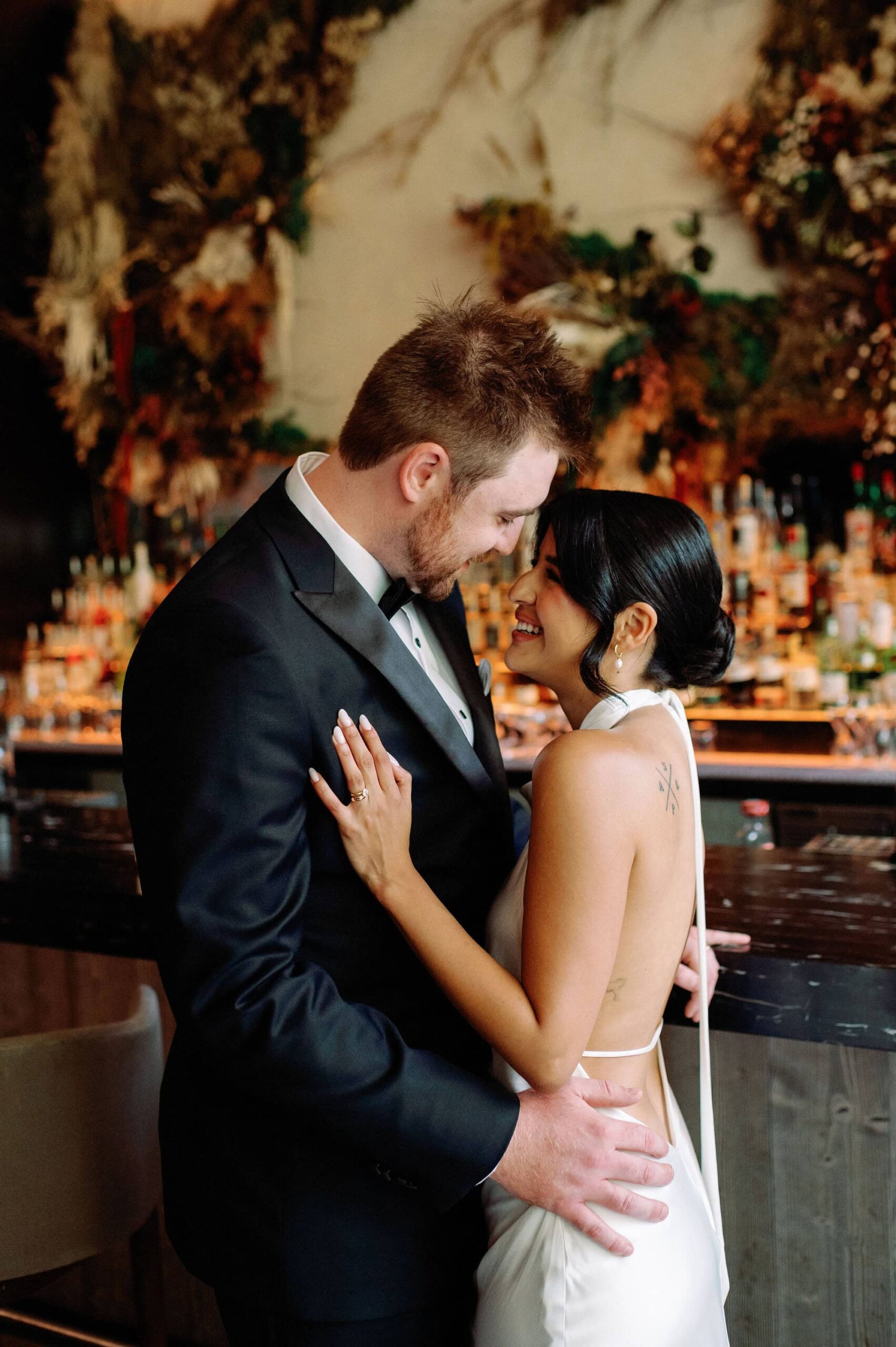 Bride and groom embrace at modern bar inside 1 Hotel Toronto