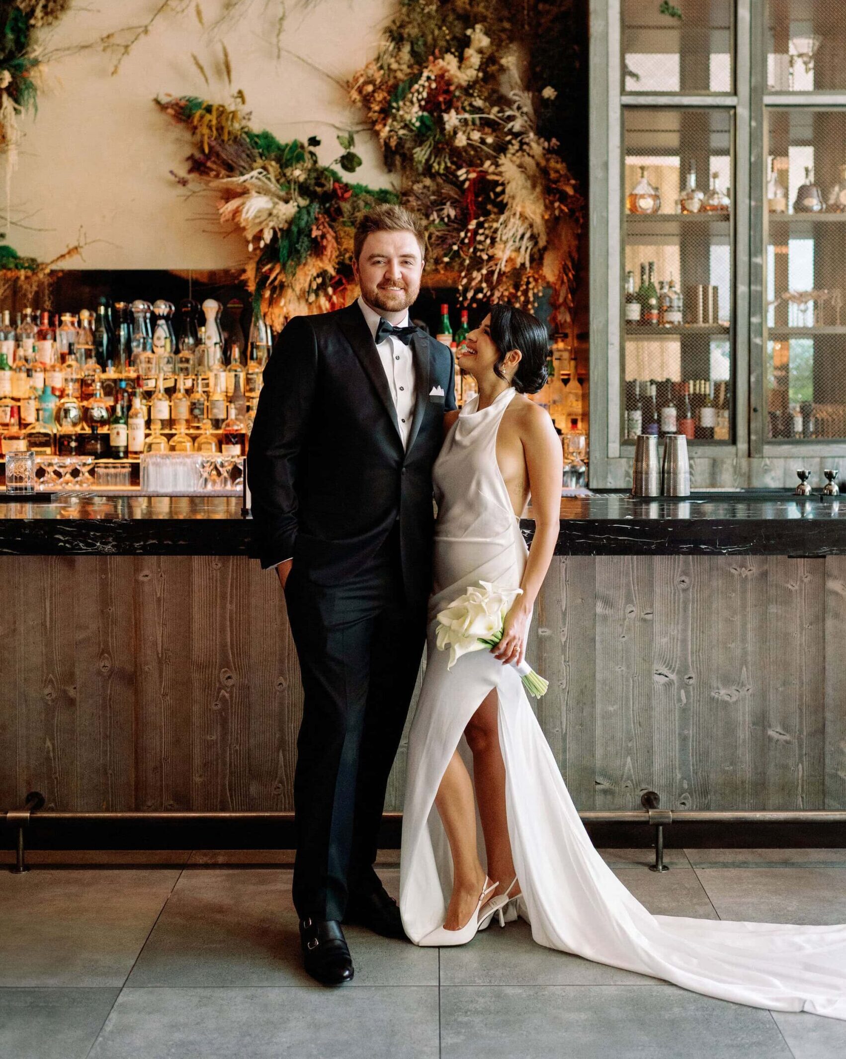 Bride and groom embrace at modern bar inside 1 Hotel Toronto