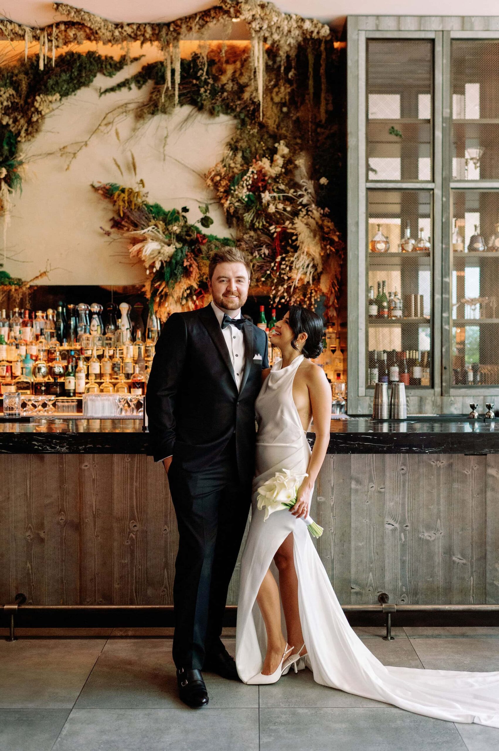 Bride and groom embrace at modern bar inside 1 Hotel Toronto