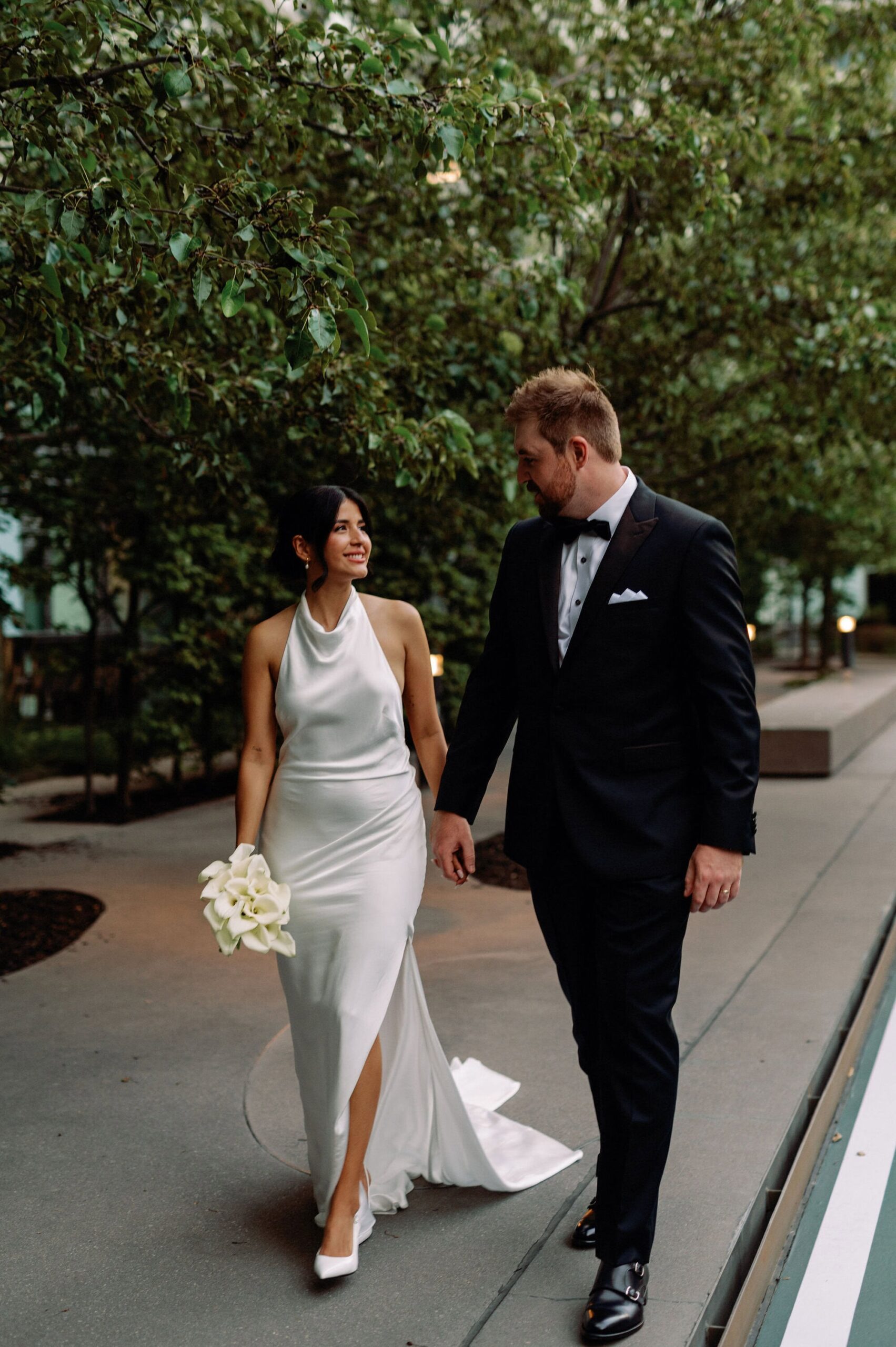 Bride and groom walking hand in hand outside 1 Hotel Toronto after ceremony