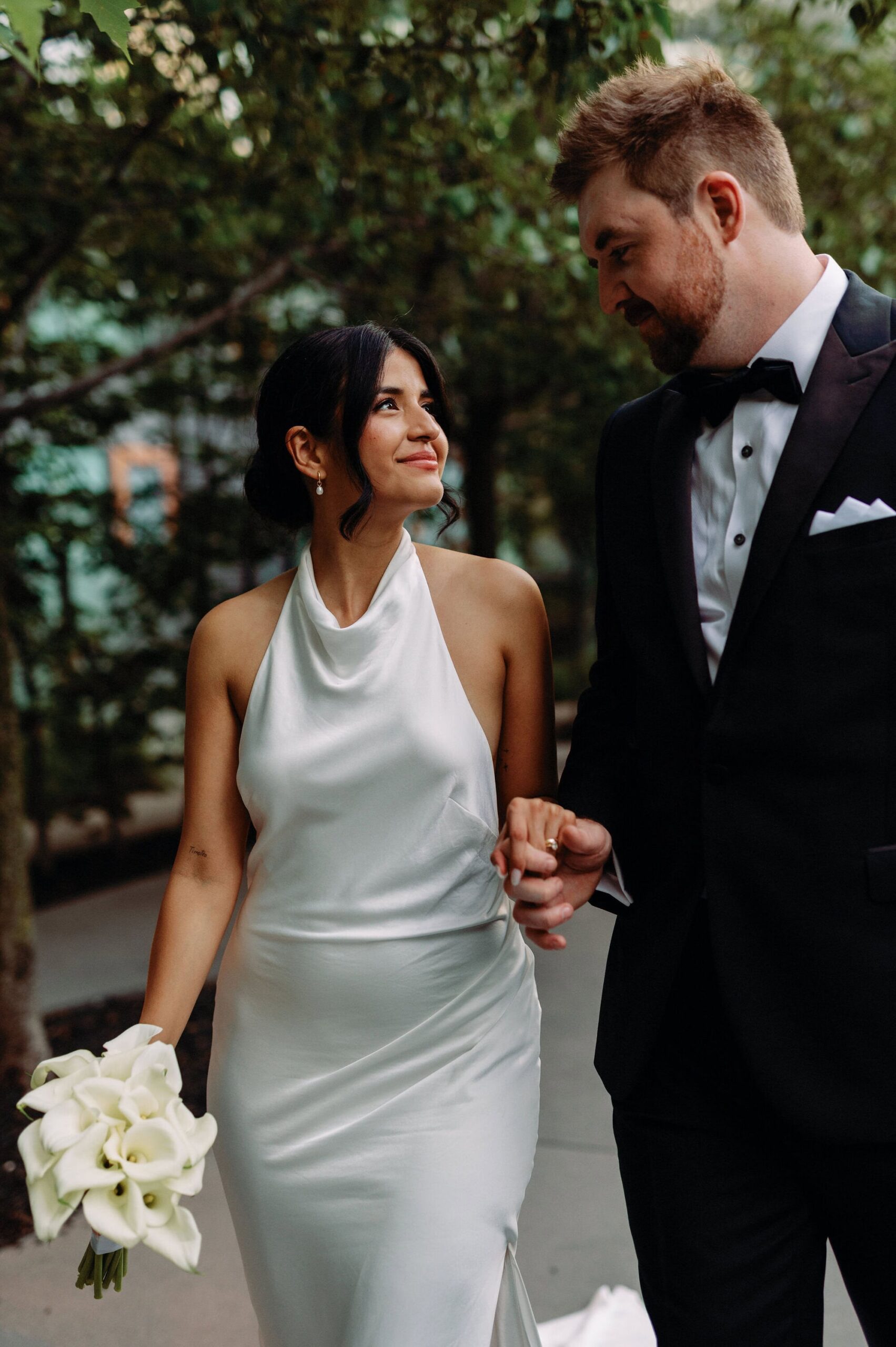 Bride and groom walking hand in hand outside 1 Hotel Toronto after ceremony
