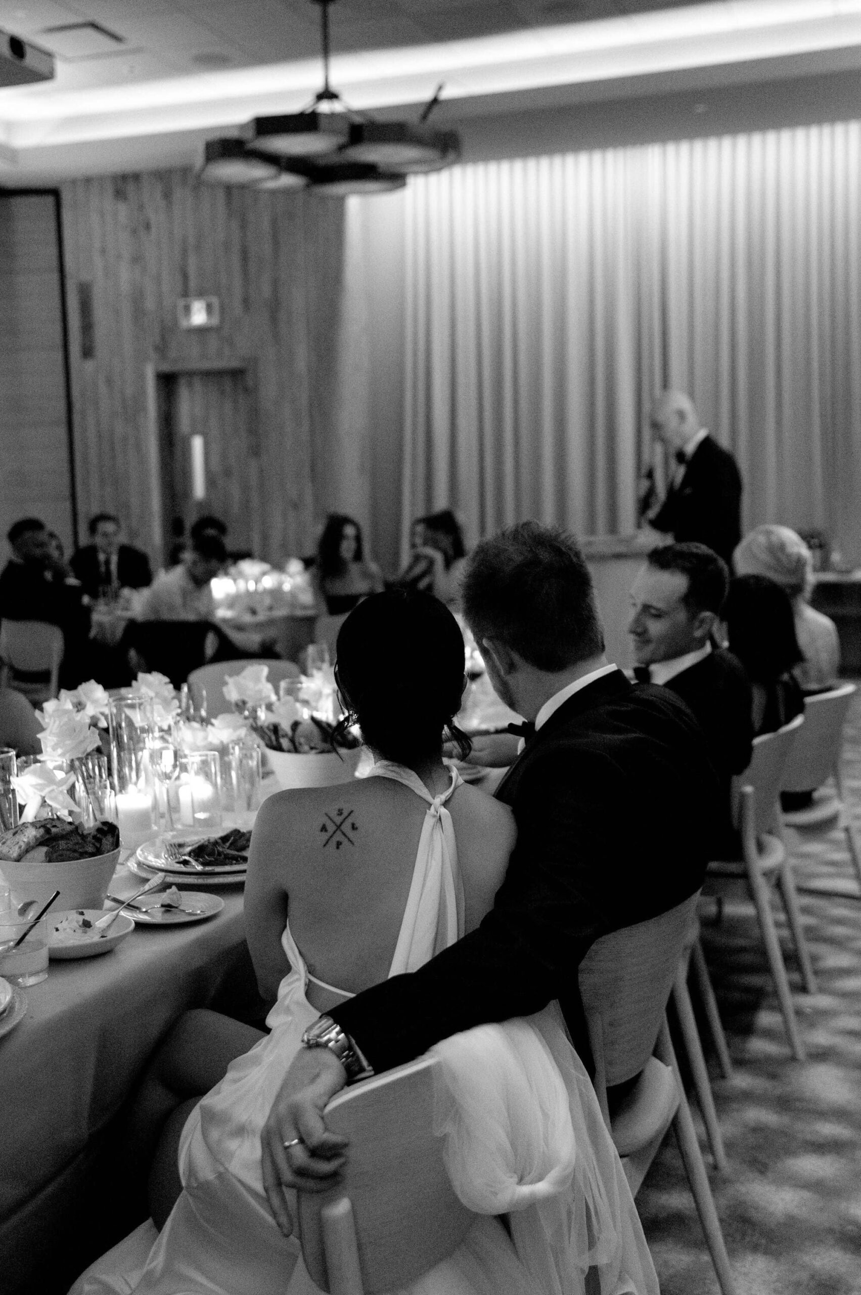 Wedding reception speech at 1 Hotel Toronto with bride and groom seated among guests