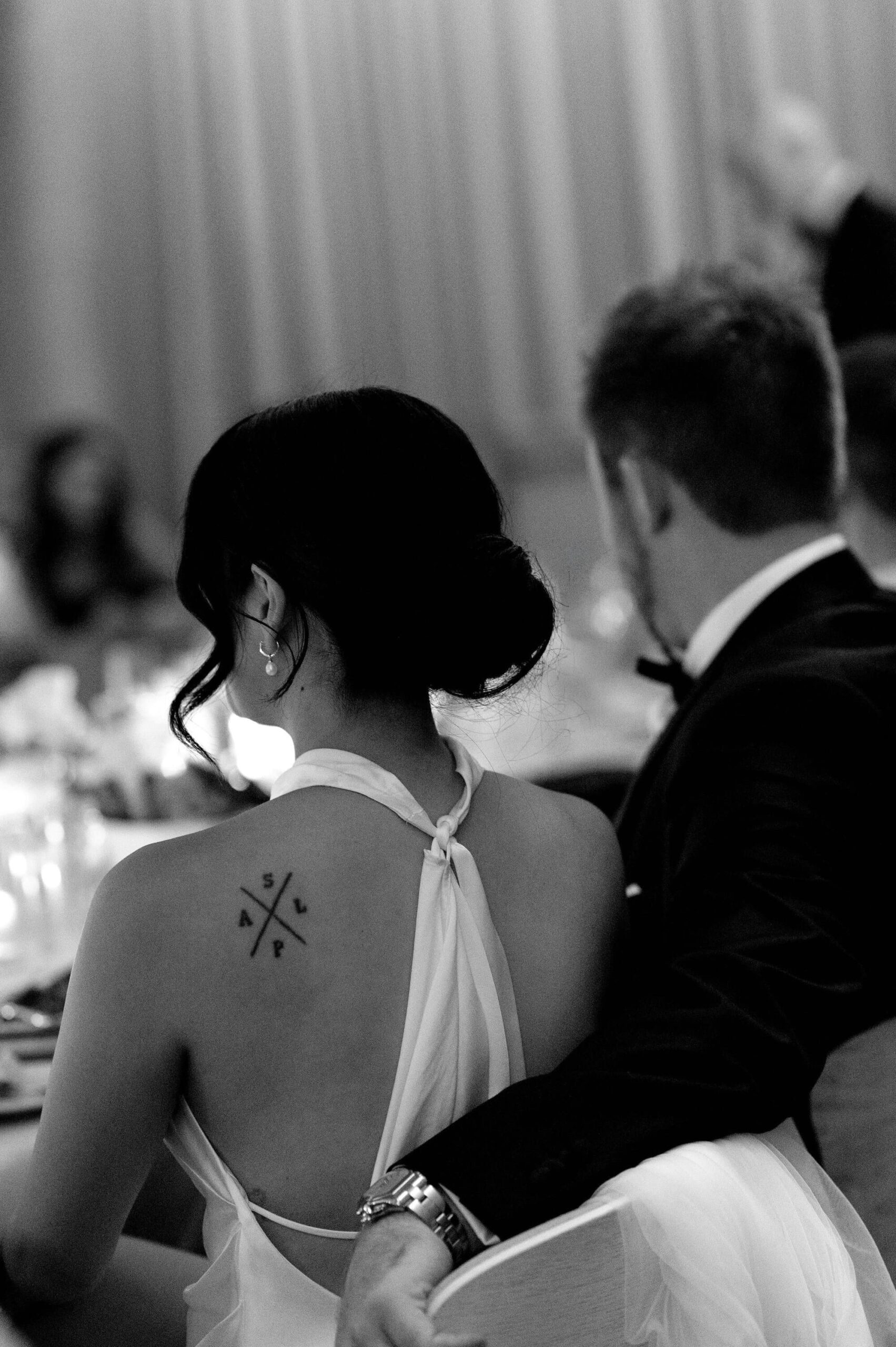 Bride and groom seated at wedding reception with tattoo detail, 1 Hotel Toronto