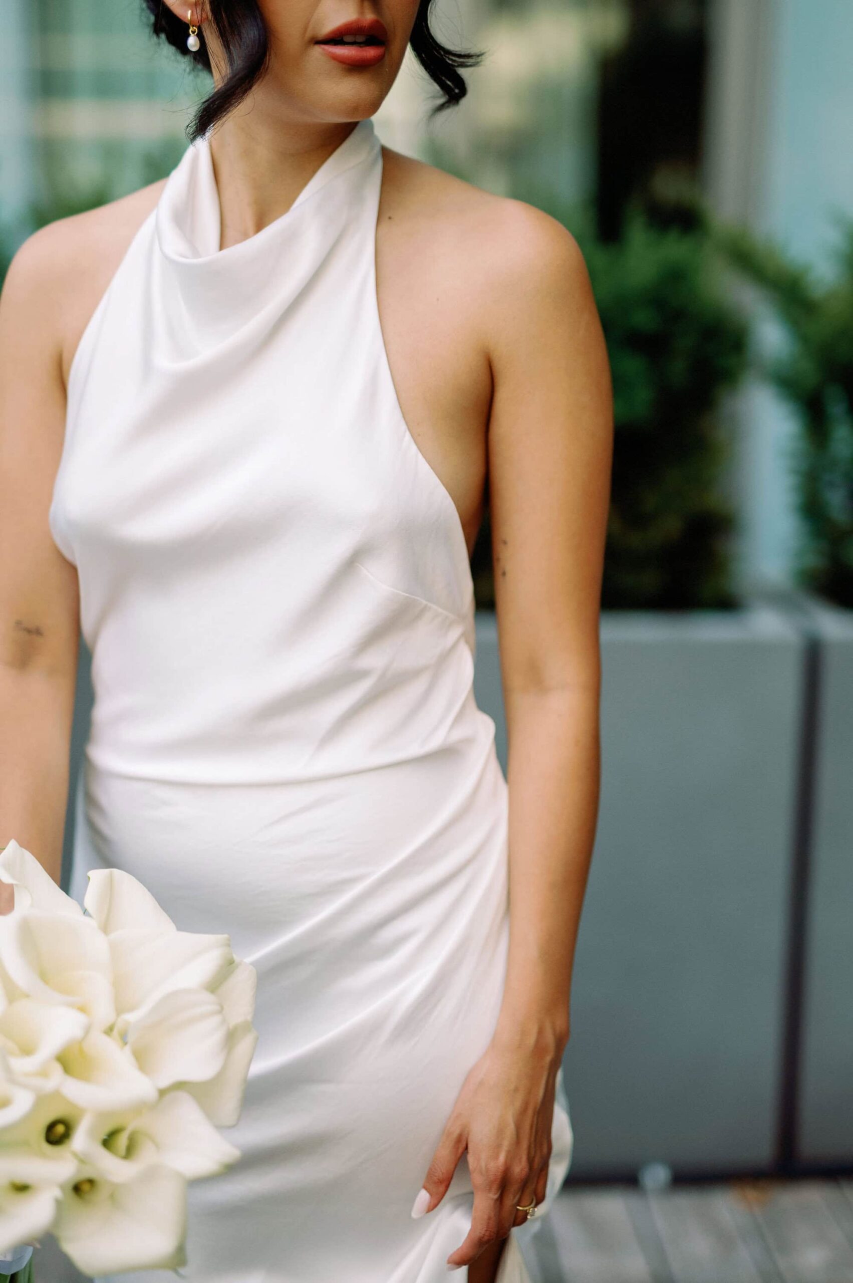 Bride holding bouquet while smiling in modern hotel suite at 1 Hotel Toronto Editorial Candid