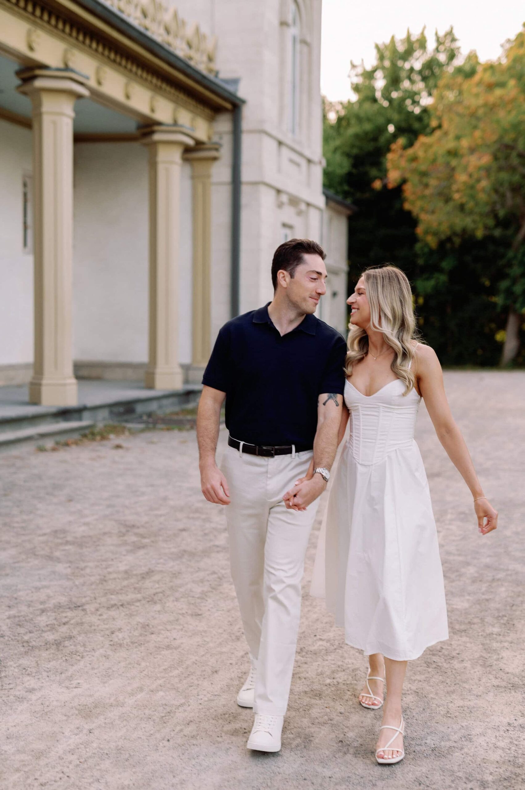 Couple walking hand in hand on the path at Dundurn Castle in Hamilton