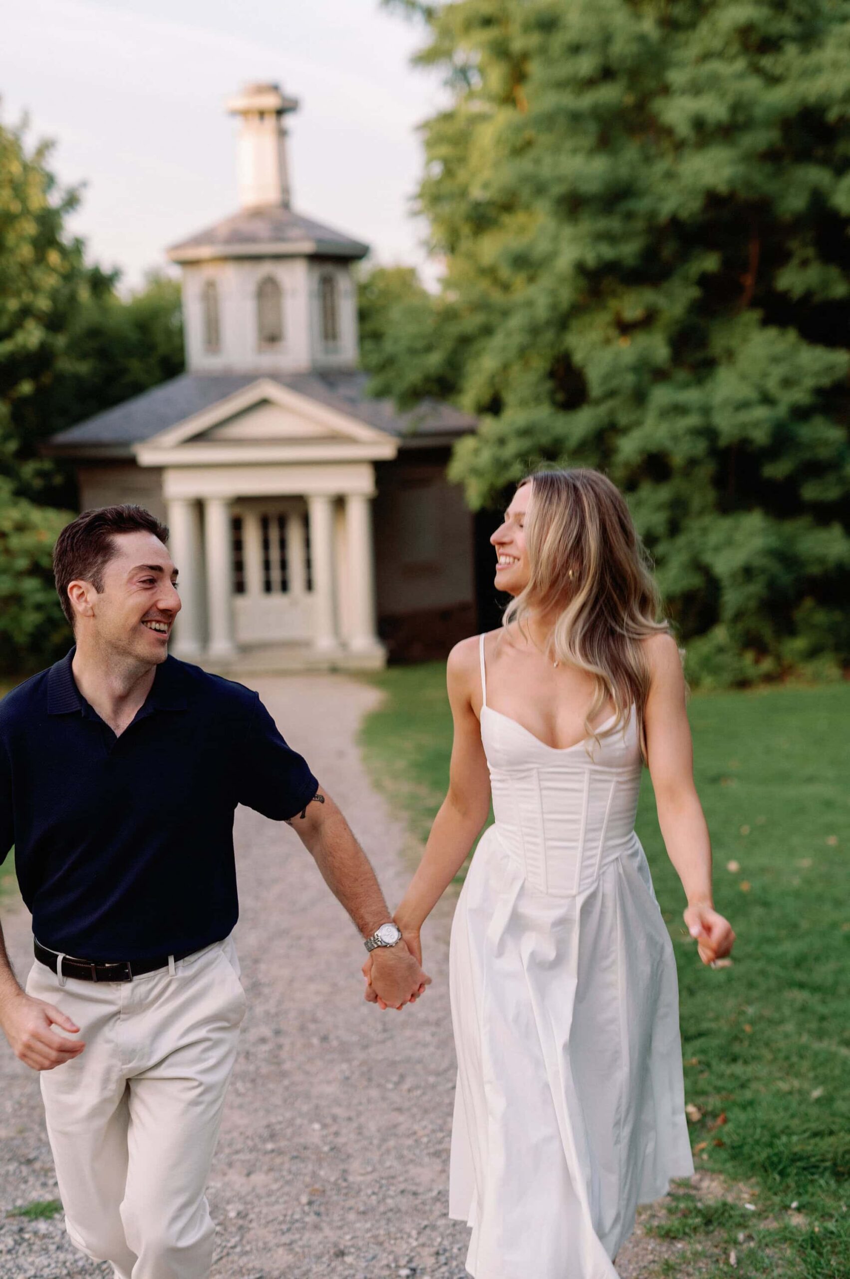 Running together across the grass in evening light at Dundurn Castle