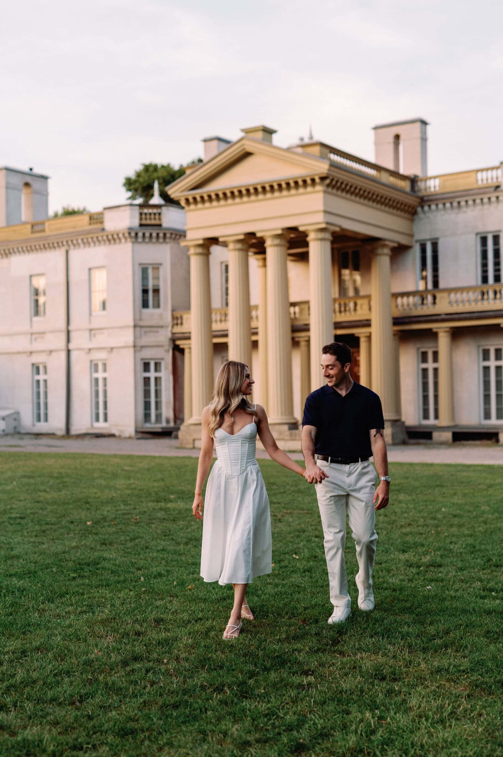 Walking toward the camera with soft greenery on the castle grounds