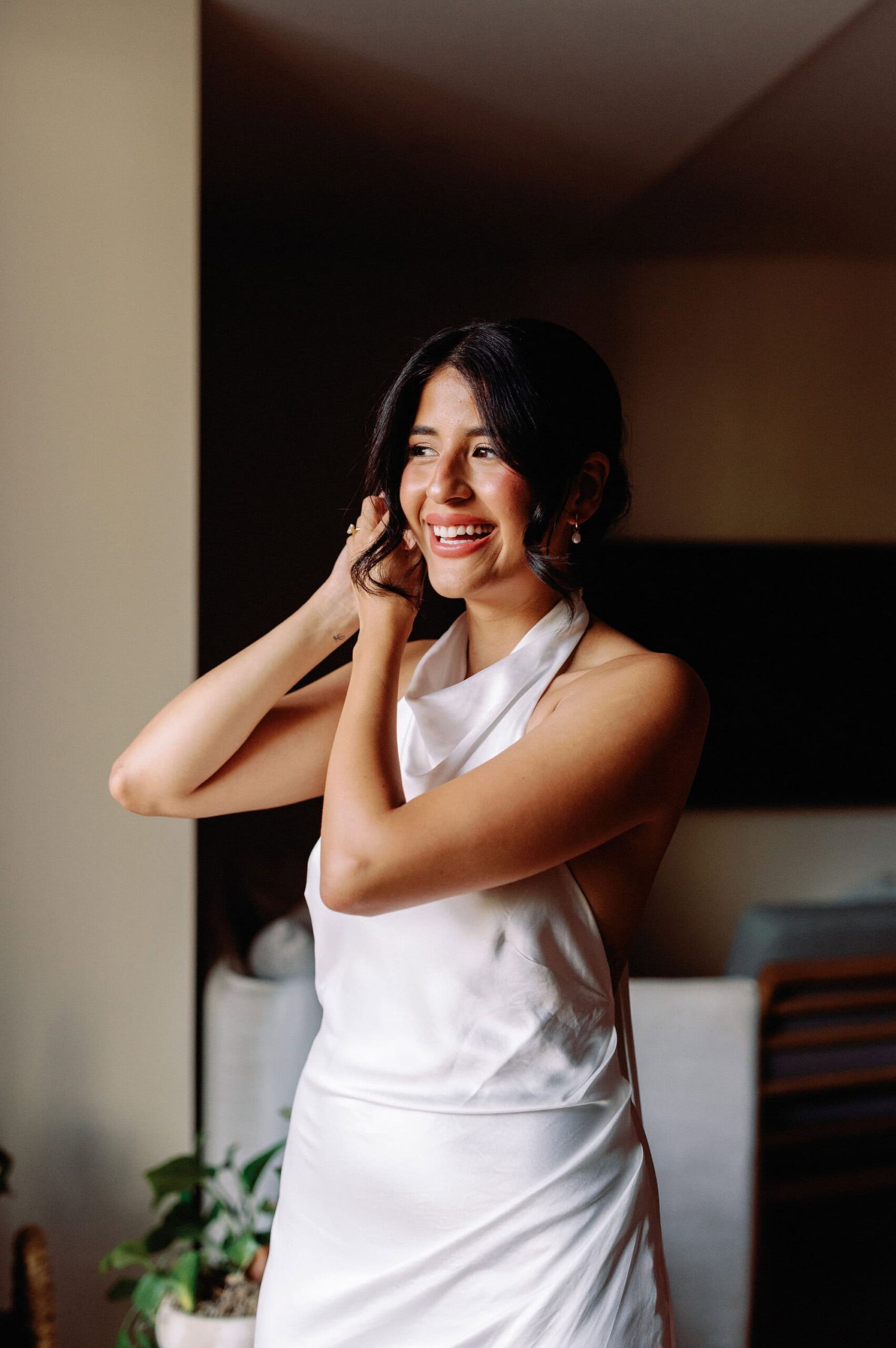 Bride putting on her earrings during getting ready moments at 1 Hotel Toronto.