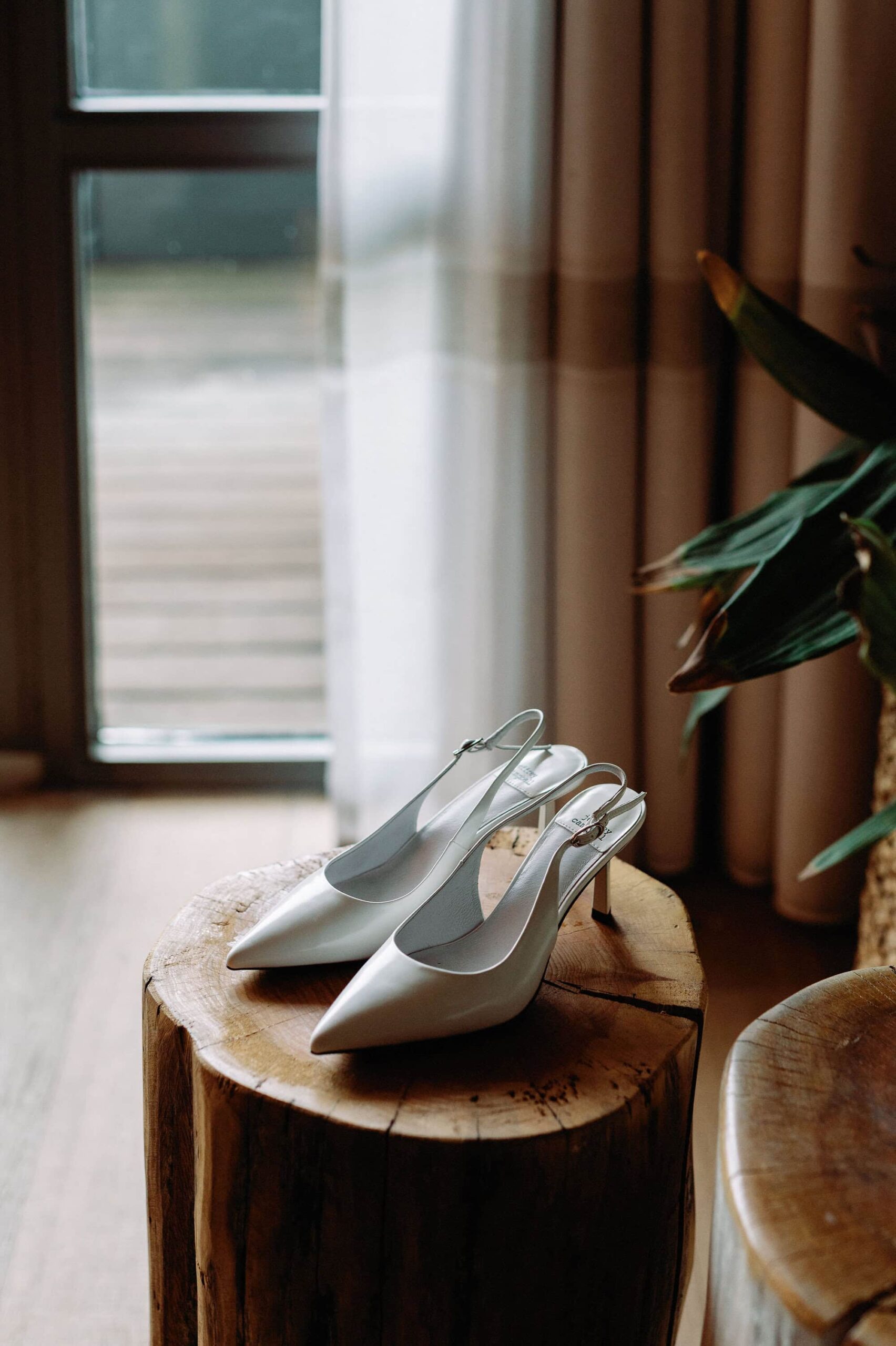 Elegant white bridal heels displayed near the window inside 1 Hotel Toronto.