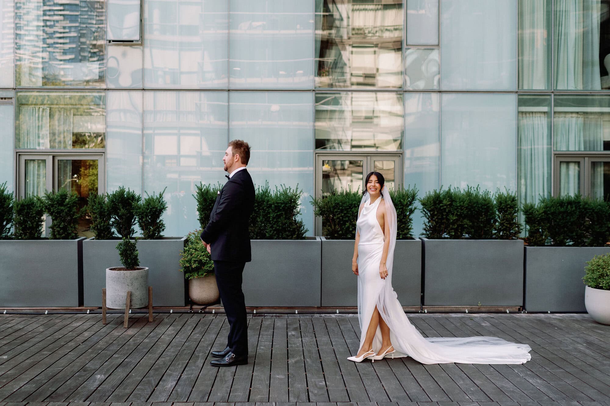 Bride approaching the groom from behind during their first look at 1 Hotel Toronto.