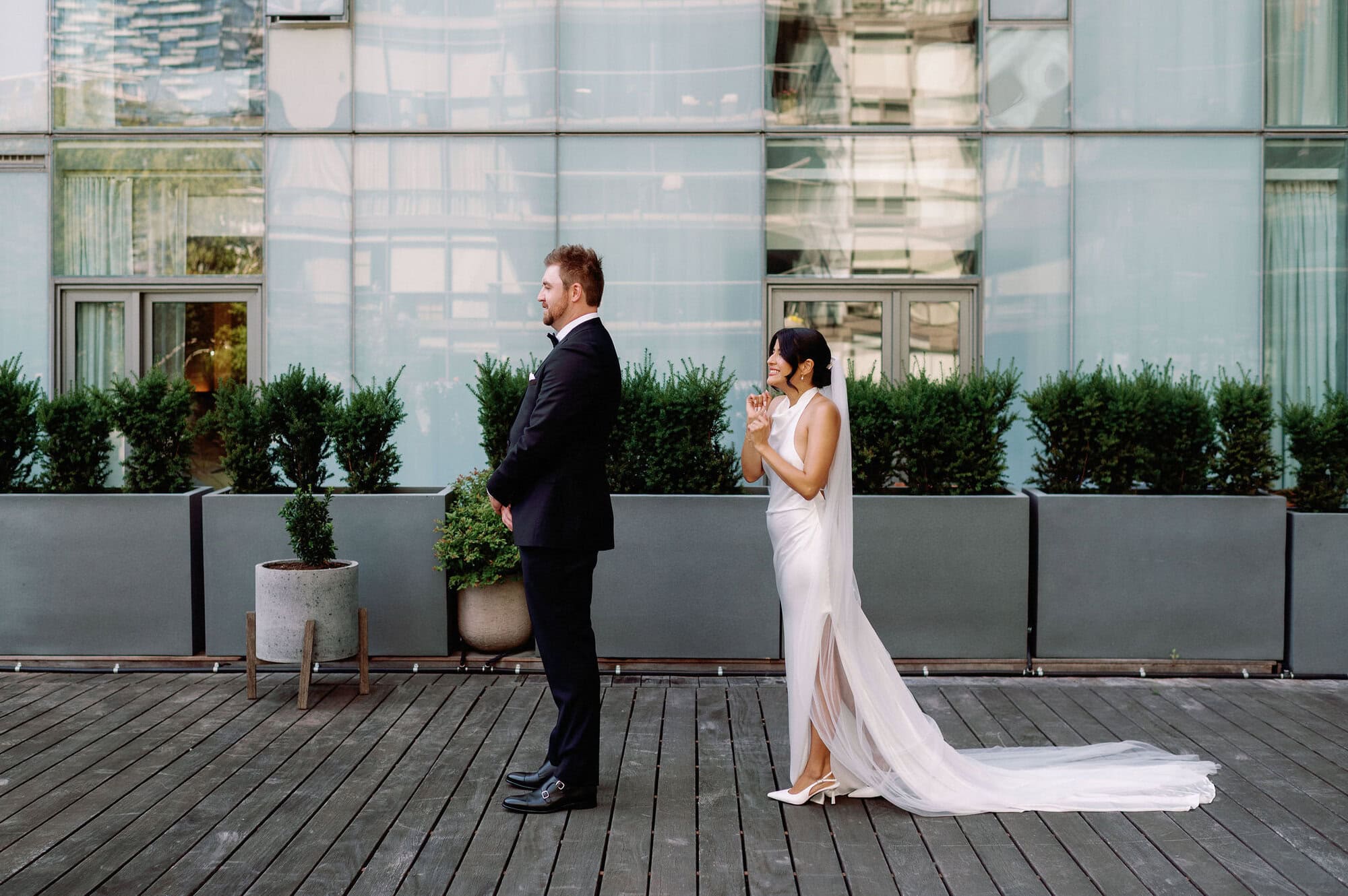 Bride approaching the groom from behind during their first look at 1 Hotel Toronto.