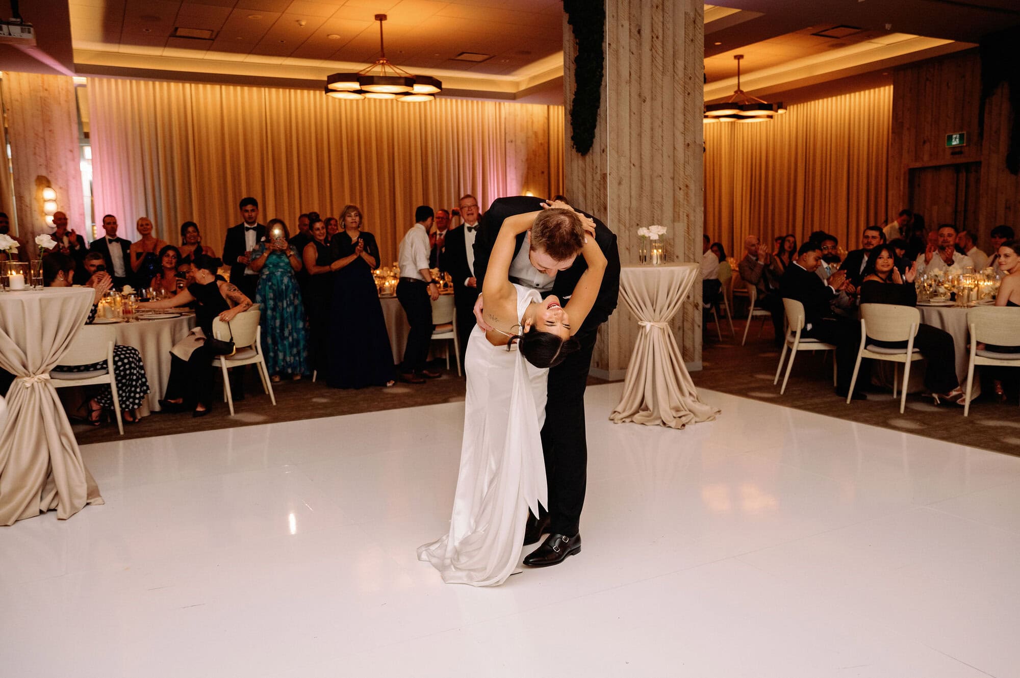 Newlyweds dancing together on the white dance floor at their 1 Hotel Toronto wedding reception.