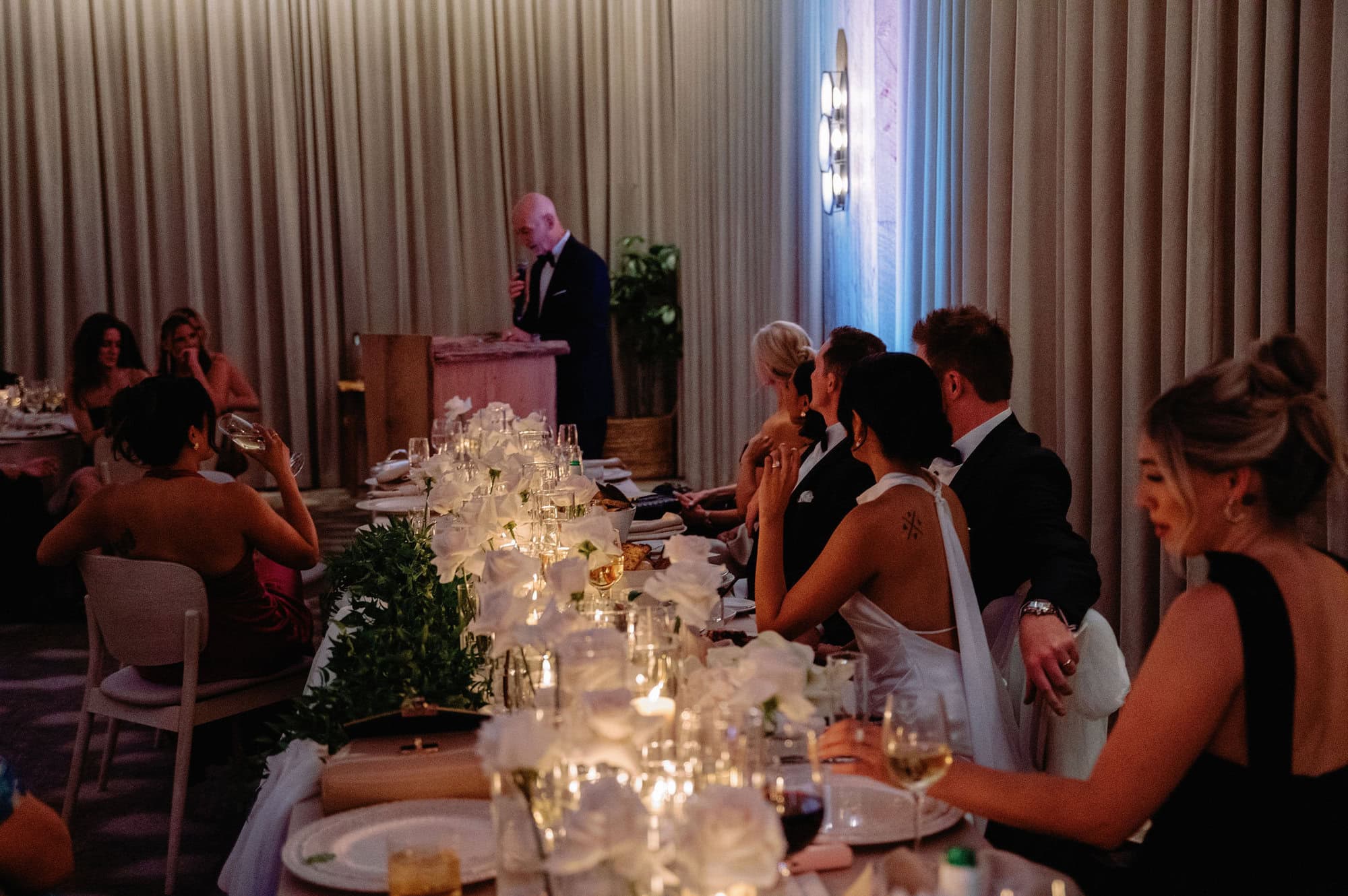 Guests watching speeches at a long candlelit dinner table at 1 Hotel Toronto.