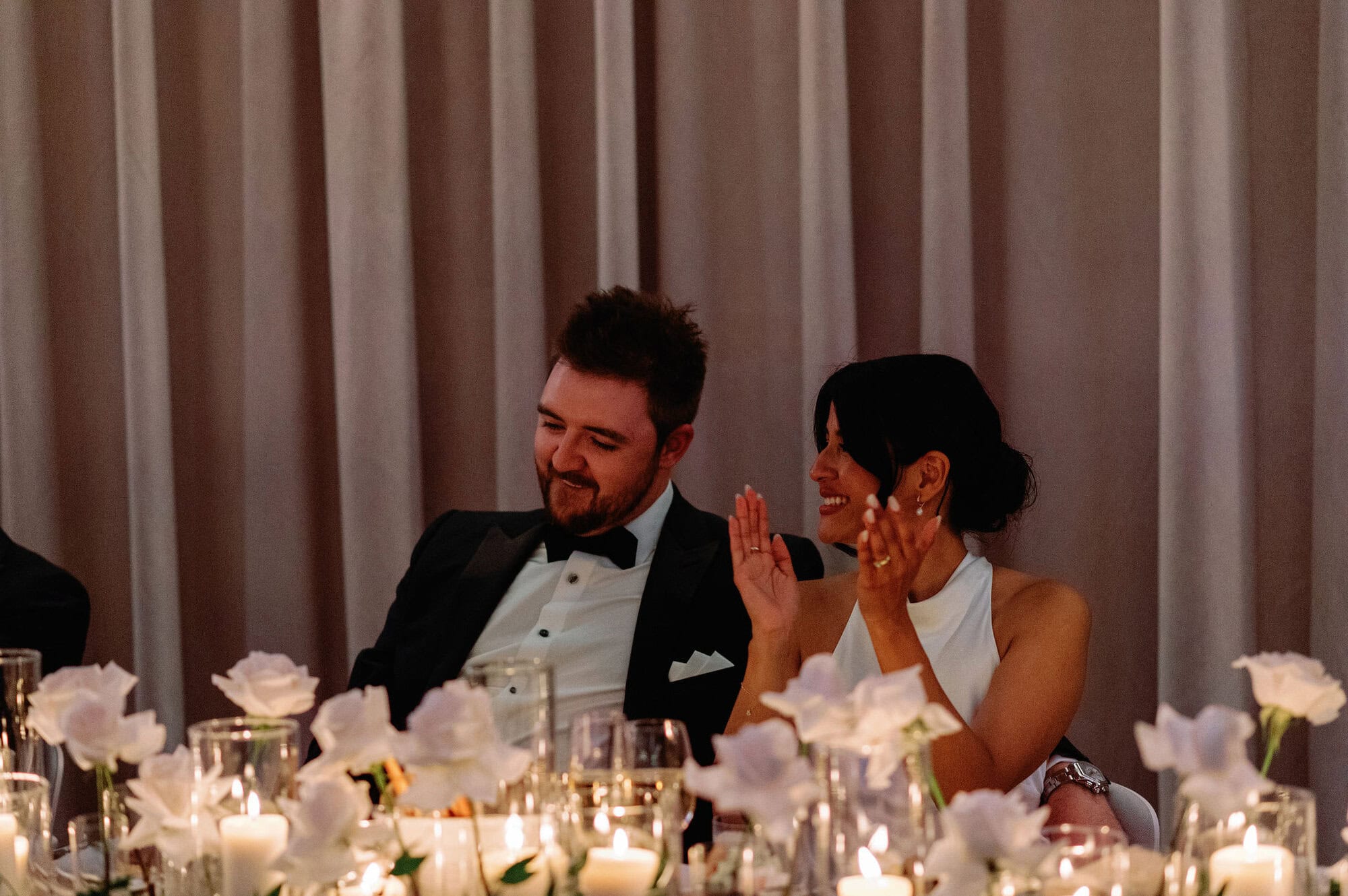 Candid of the bride and groom listening to speeches at their 1 Hotel Toronto wedding.