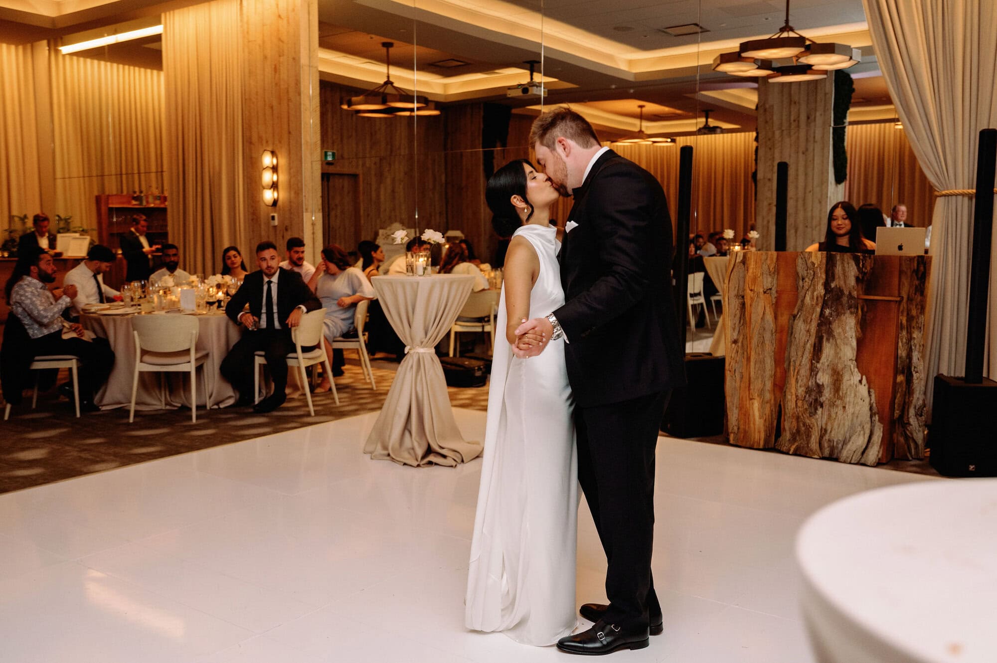 Newlyweds dancing together on the white dance floor at their 1 Hotel Toronto wedding reception.