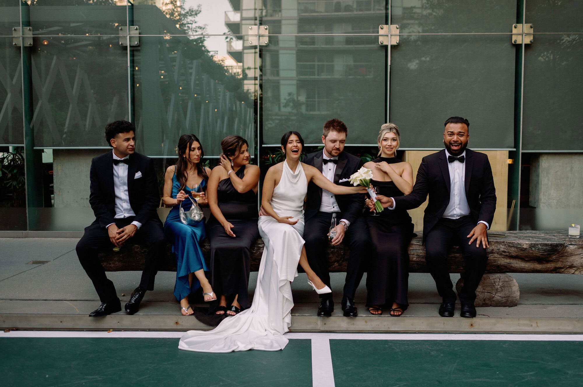 Wedding party sitting together with the bride and groom outside 1 Hotel Toronto during portraits.
