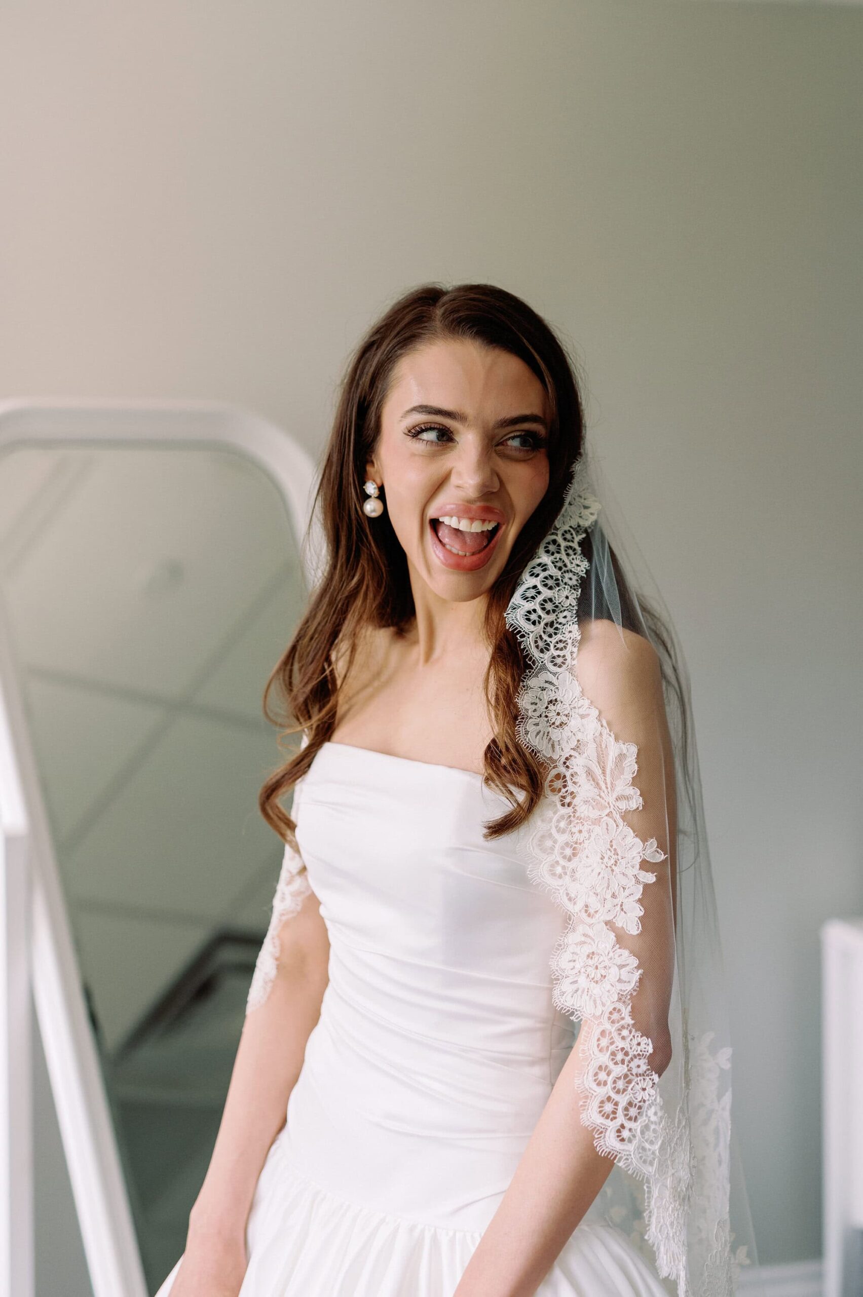 Bride smiling in her lace sleeve gown during getting ready moments at Harding Waterfront Estate