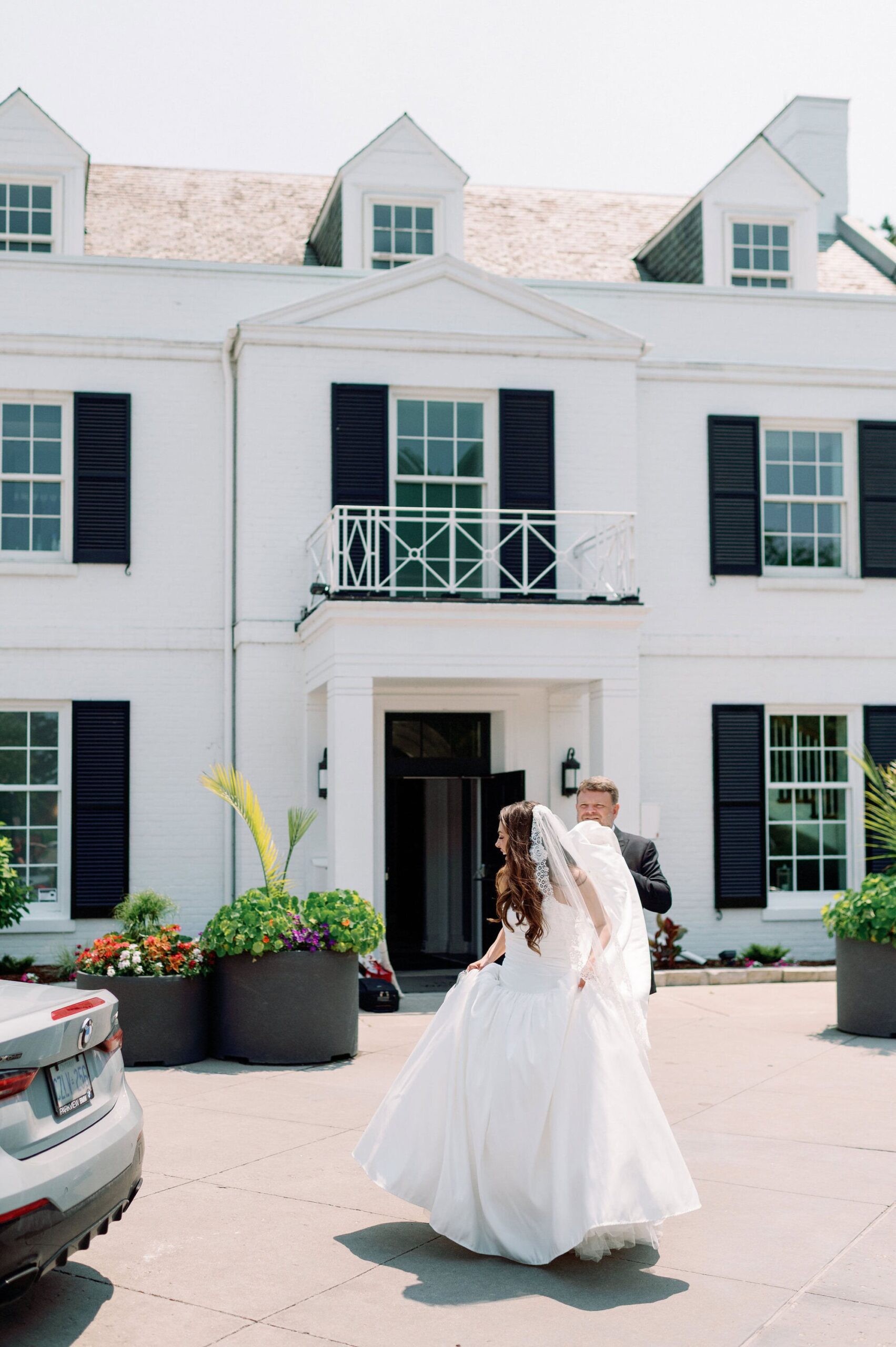 Bride entering the front doors of Harding Waterfront Estate for her wedding celebration.