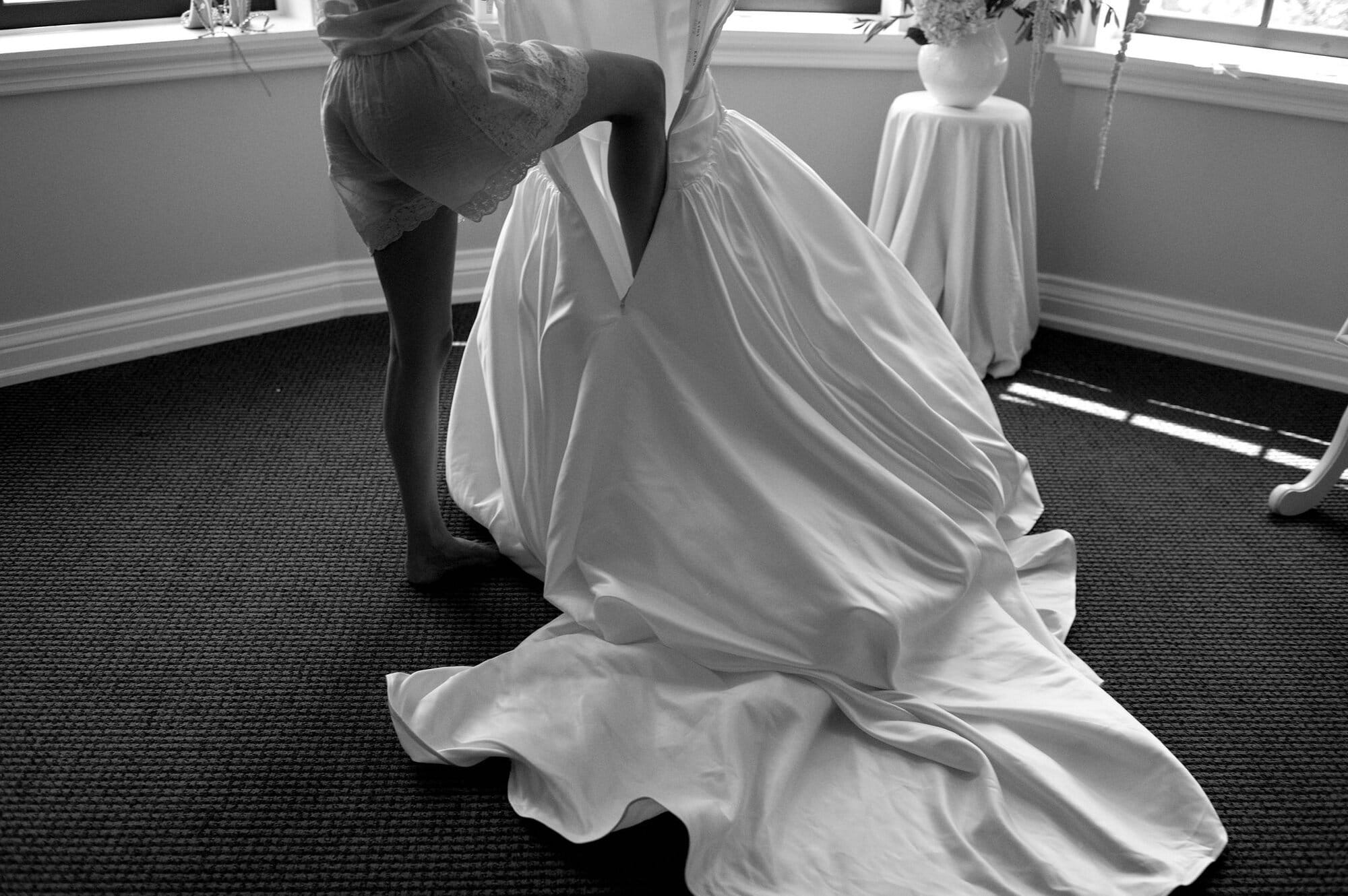 Close up of the wedding gown being lifted during getting ready at Harding Waterfront Estate