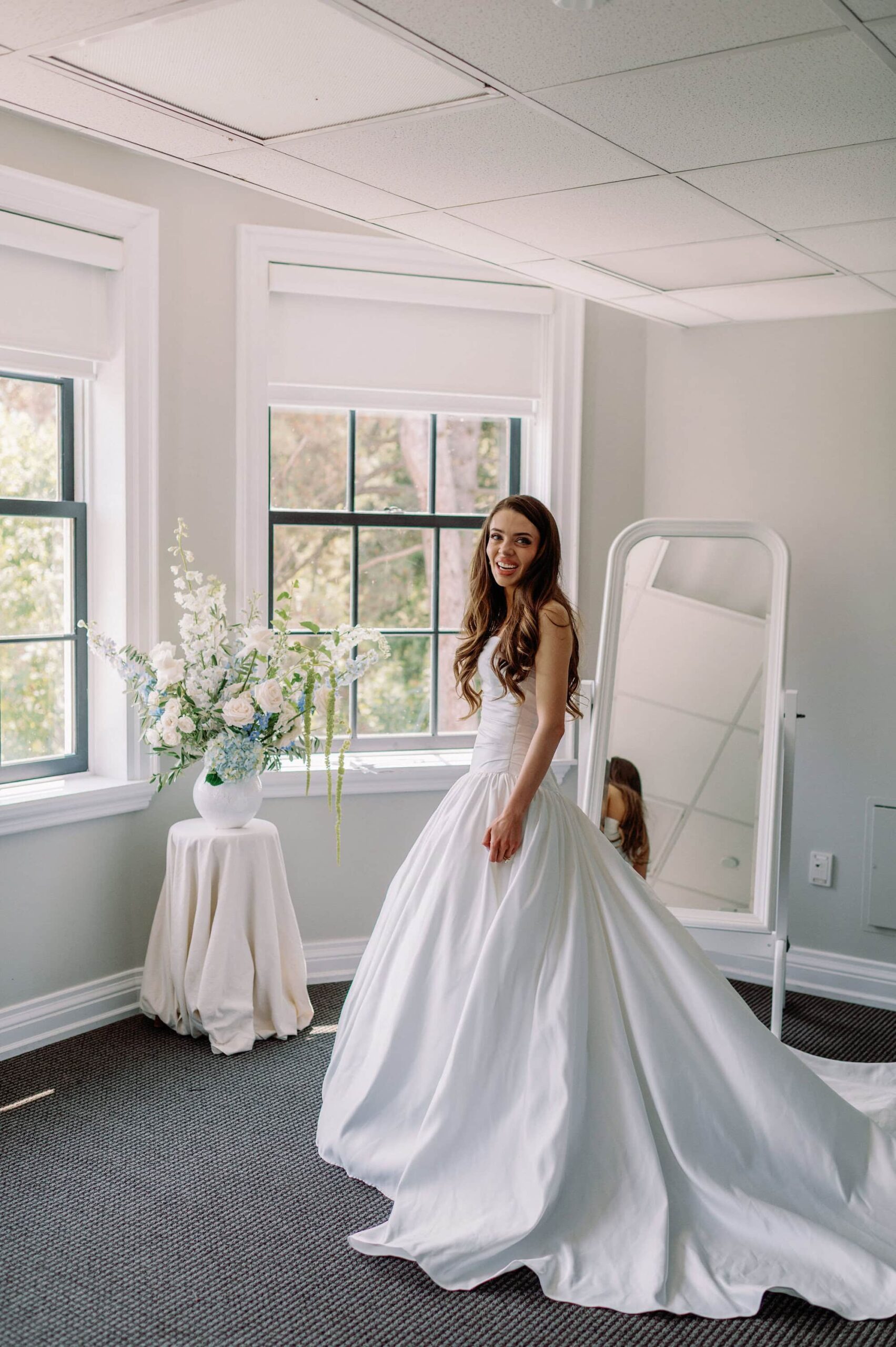 Bride standing in front of the mirror in her wedding gown inside the bridal suite at Harding Waterfront Estate.