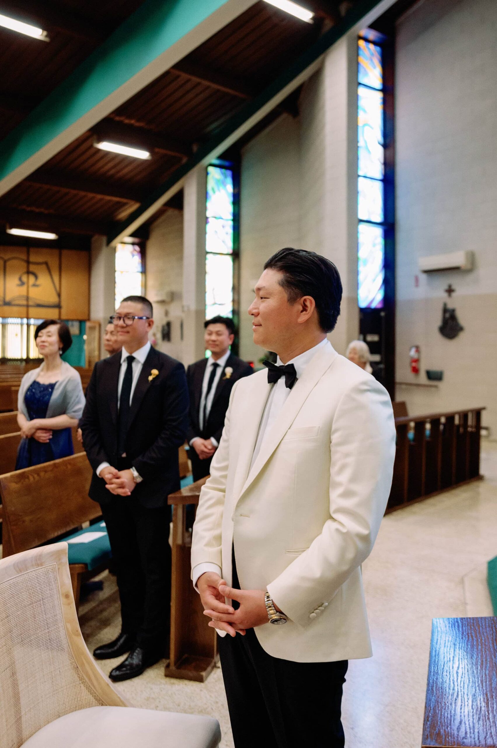 Groom standing at the altar watching guests arrive before the ceremony.