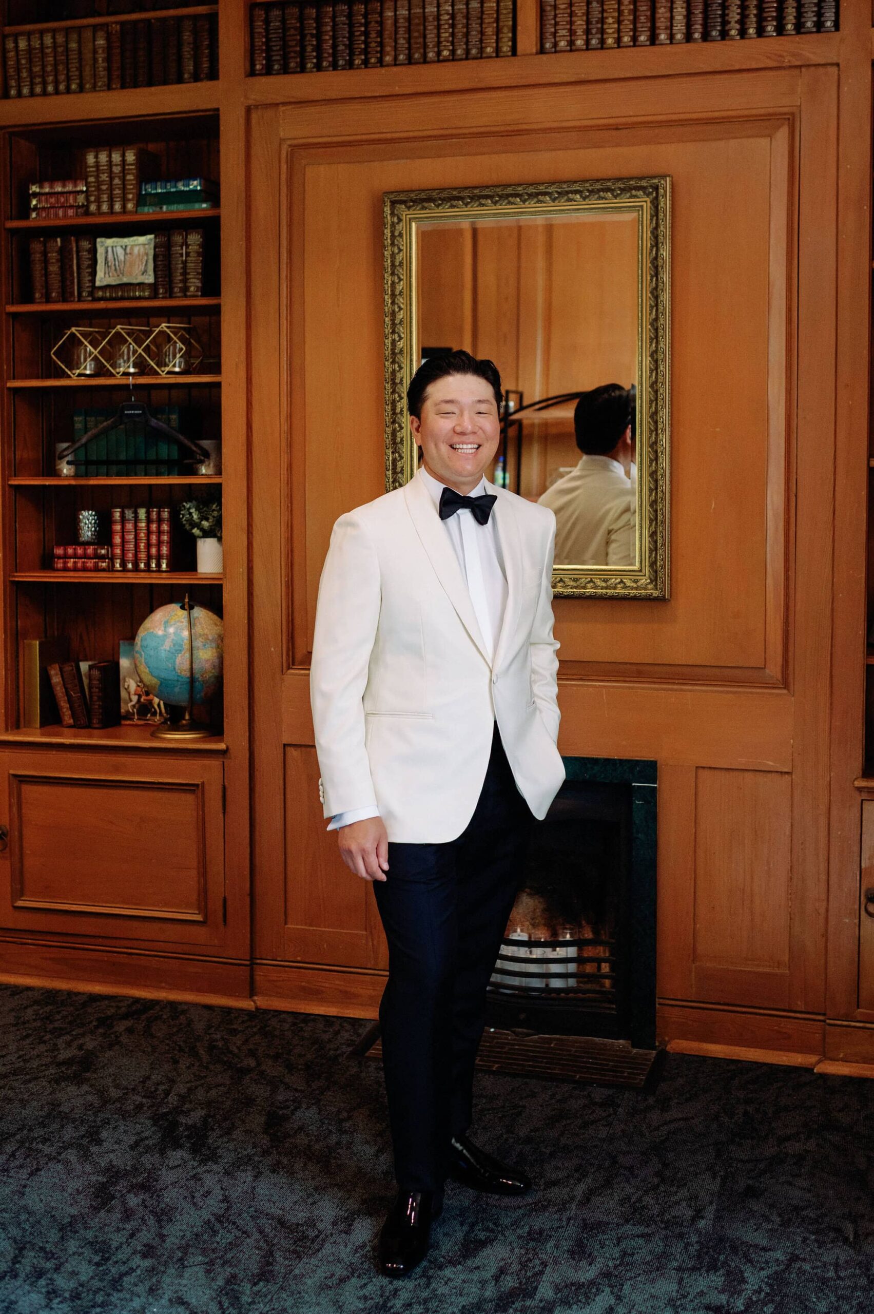 Full length groom portrait in the elegant library at Harding Waterfront Estate.