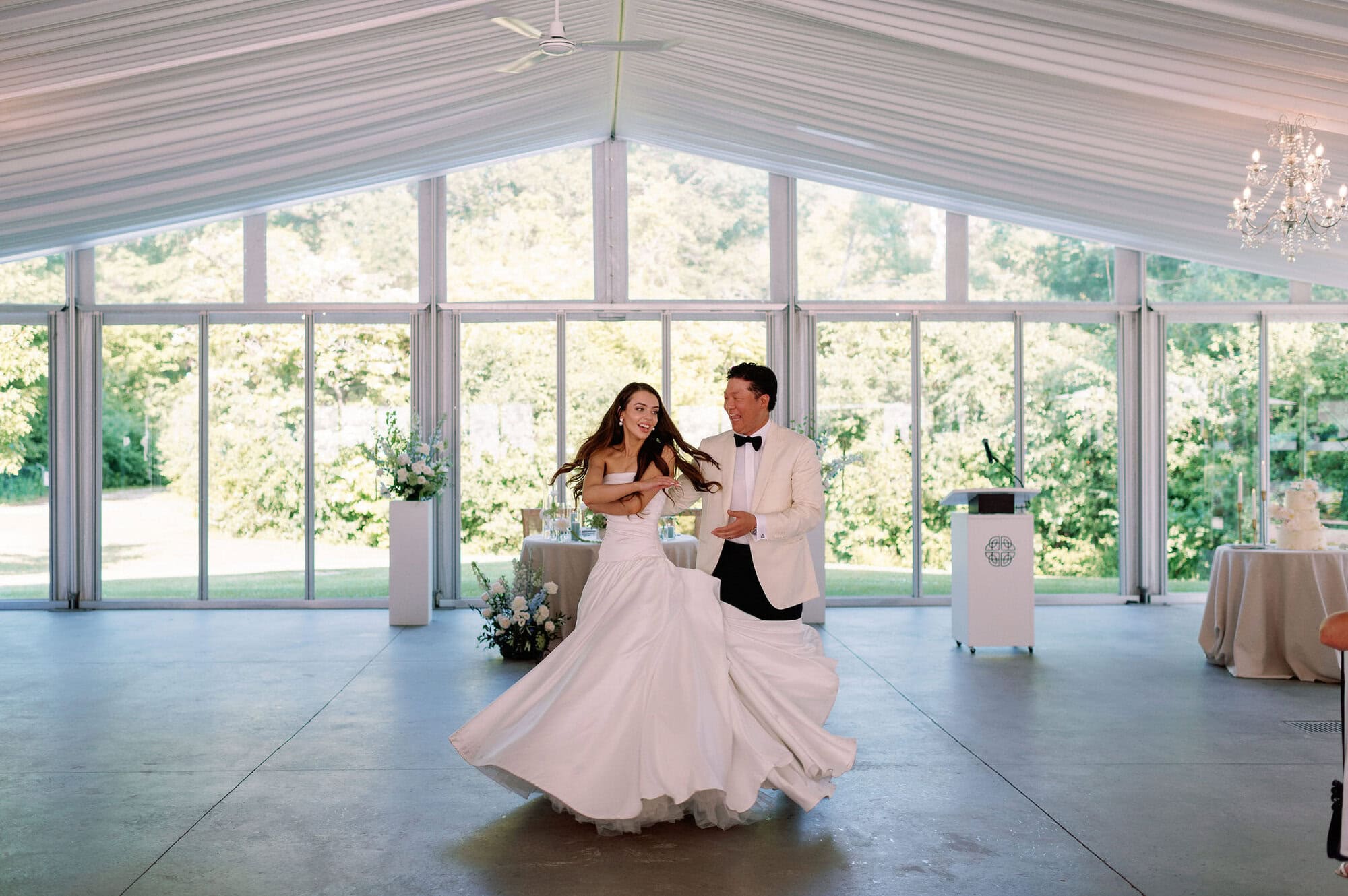 Bride and groom dancing in the bright tented reception space at Harding Waterfront Estate.
