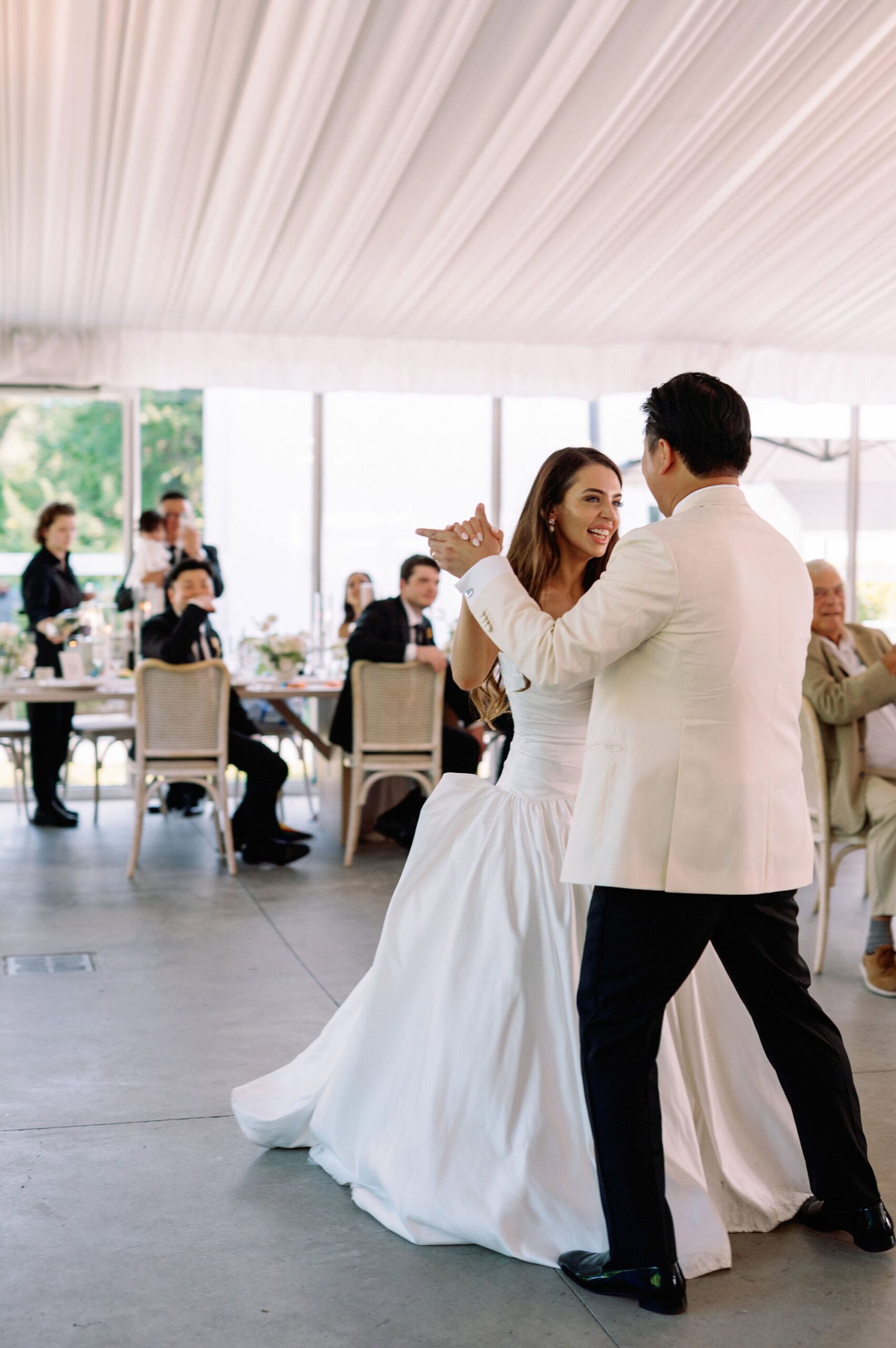 Bride and groom sharing a joyful dance inside the tented reception at Harding Waterfront Estate in Mississauga.