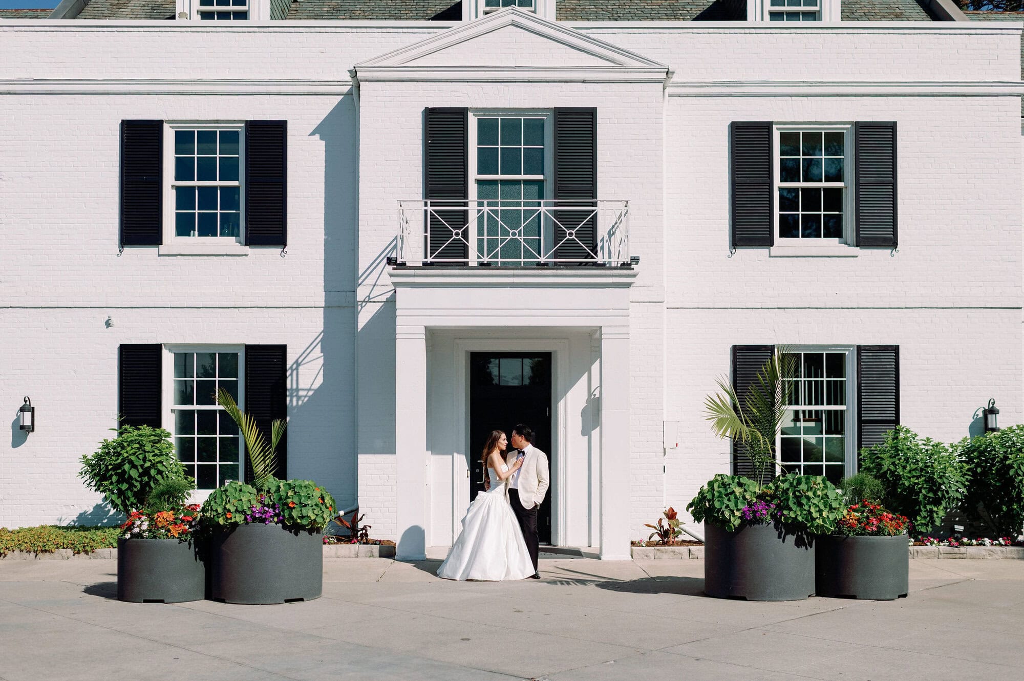 Bride and groom walking together outside the historic Harding Waterfront Estate.