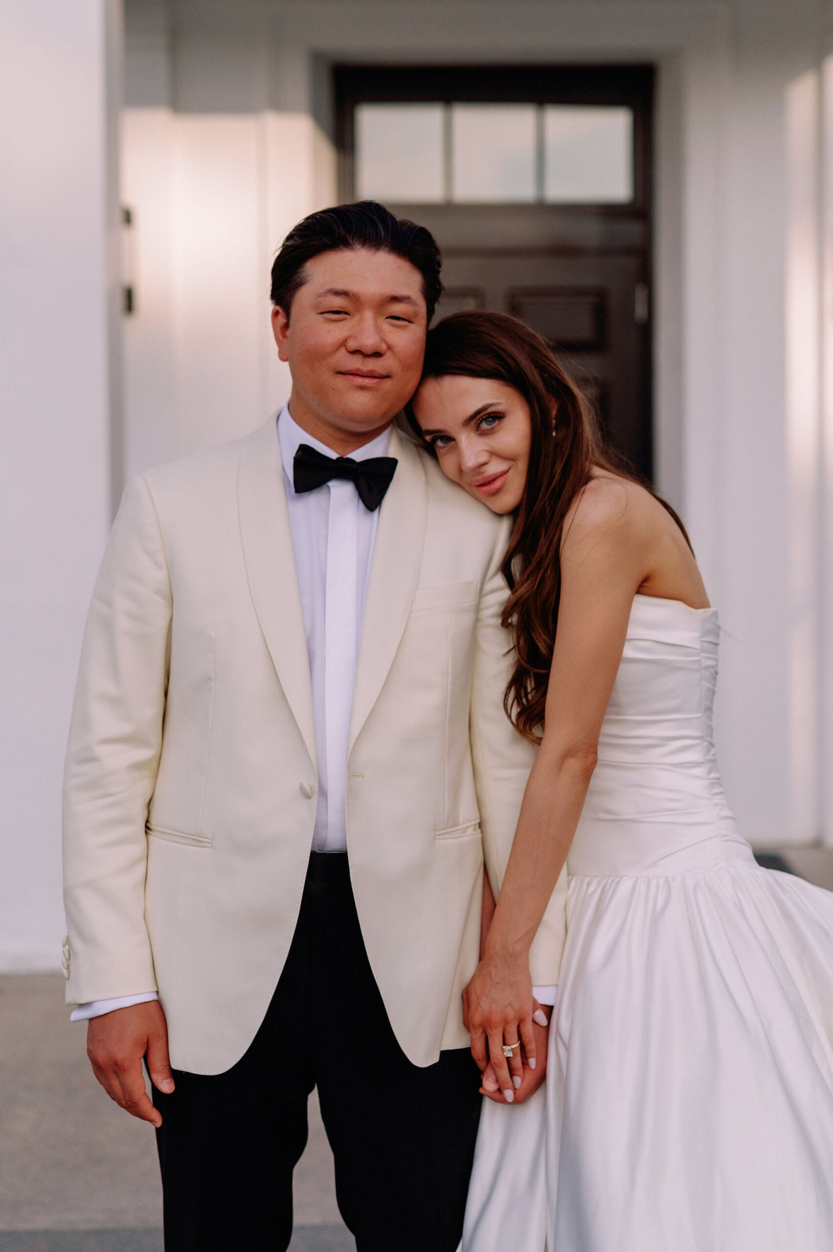 Bride leaning on the groom during a quiet portrait outside Harding Waterfront Estate in Mississauga.